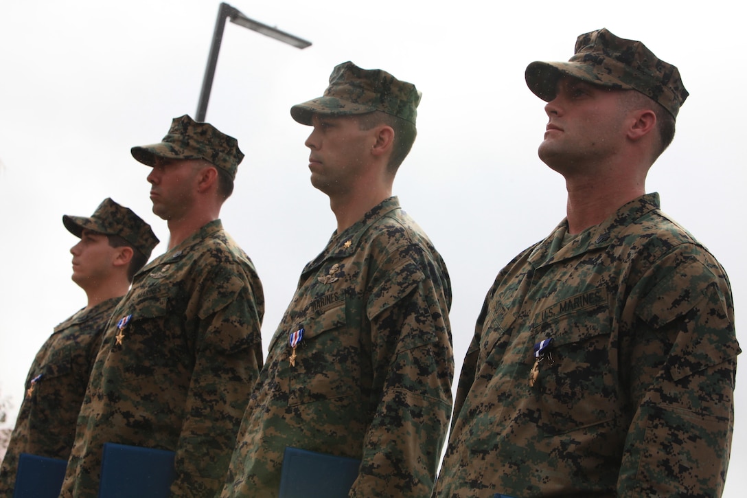 MARINE CORPS BASE CAMP PENDLETON, Calif.- (From left to right) Hospitalman 1st Class Patrick B. Quill, SSgt. Frankie J. Shinost, Maj. James T. Rose and Sgt. William B. Soutra of 1st Marine Special Operations Battalion, U.S. Marine Corps Forces, Special Operations Command, stand at attention after being awarded the nation's second and third highest awards for combat valor by Secretary of the Navy Ray Mabus at 1st MSOB headquarters aboard Camp Pendleton, Calif. Dec. 3. Soutra was awarded the Navy Cross, and Rose, Shinost and Quill were each awarded the Silver Star for extraordinary heroism exhibited during a combat mission in Helmand Province, Afghanistan nearly two years ago (U.S. Marine Corps photo by Cpl. Kyle McNally/Released).