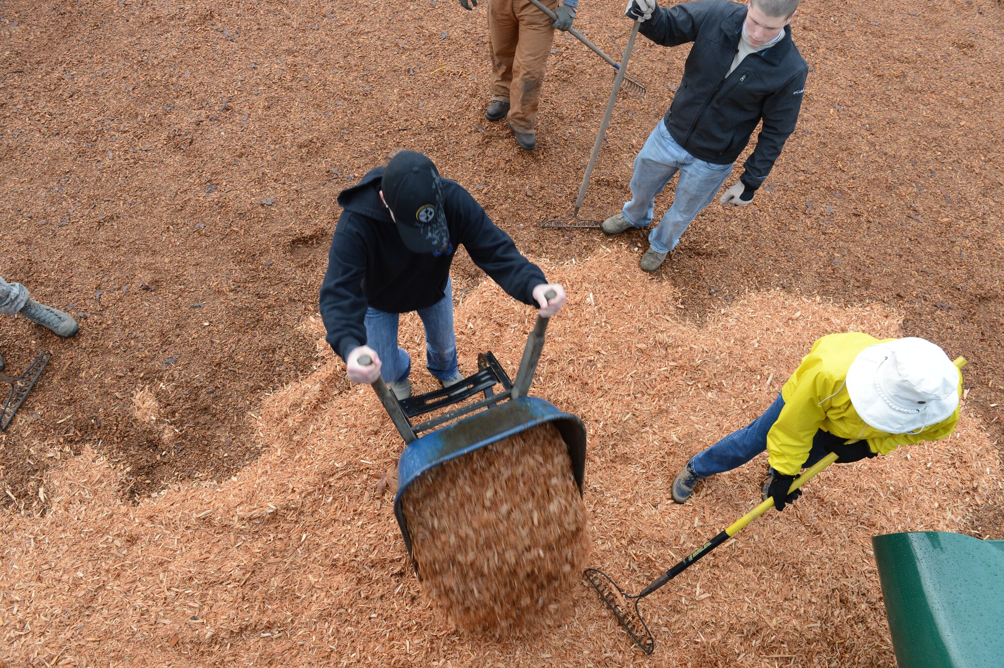 Airmen from the 62nd Airlift Wing, the 627th Air Base Group, and Western Air Defense Sector, from Joint Base Lewis-McChord, Wash., work alongside members of the Rotary Club to spread wood chips on the playground, Nov. 30, 2012, at Ft. Steilacoom Park in Lakewood, Wash. The Airmen and Rotary members created a new bed of cushioning wood chips, as well as installed a new slide in an effort to revitalize the children's playground. (U.S. Air Force photo/Staff Sgt. Sean Tobin)