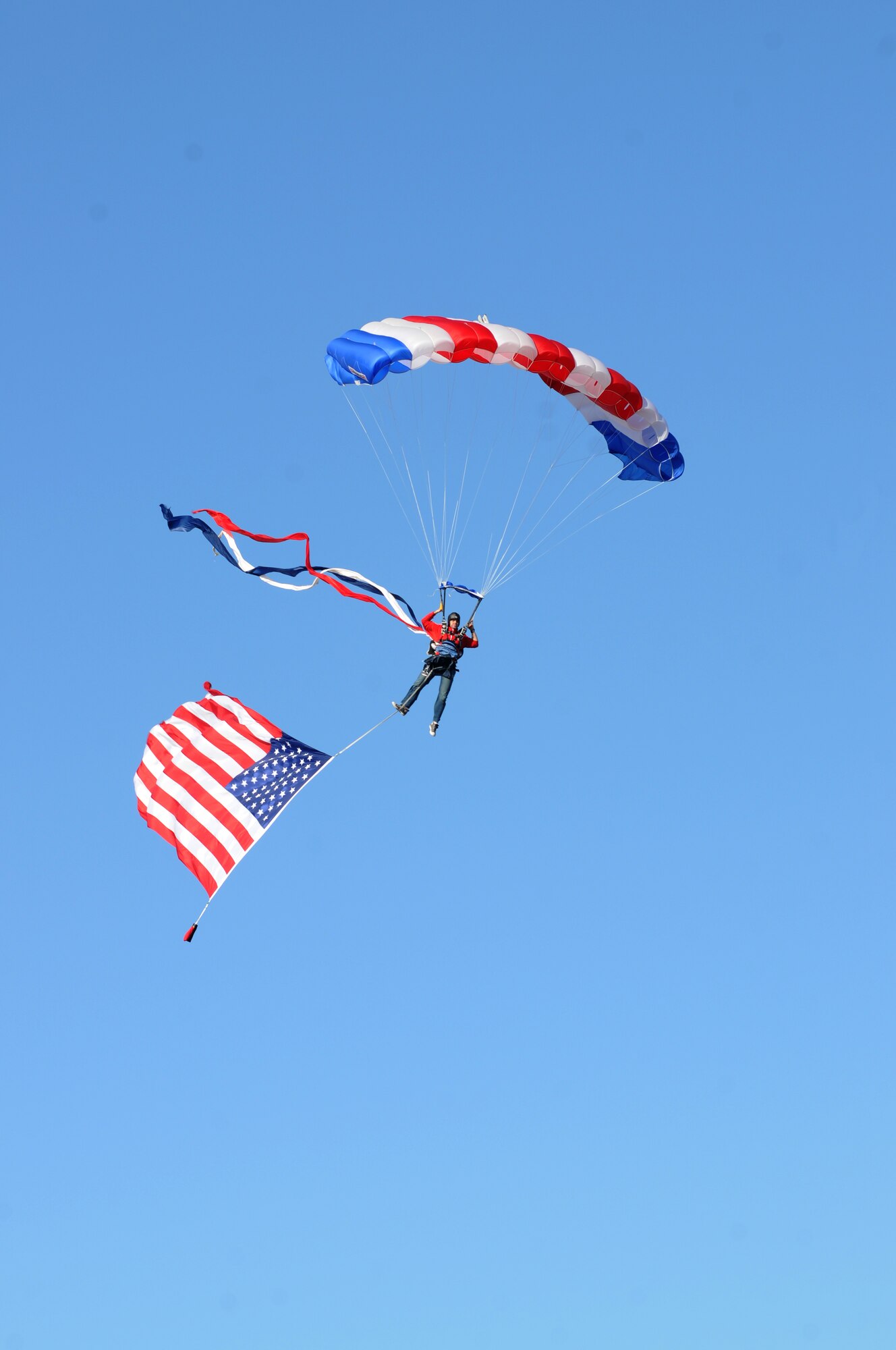 Vince Moore, member of the All-American Skydiving Team, parachutes his way onto the football field carrying the American Flag during the pre-game celebration at the 2012 Mississippi Bowl at the Biloxi High School football stadium Dec. 2, 2012. Participation from Keesler Air Force Base, Miss., included the 50-State Flag Team, the Honor Guard, a C-130J Hercules fly over by the 403rd Wing and a drill down performance by the 81st Training Group.  (U.S. Air Force photo by Kemberly Groue)