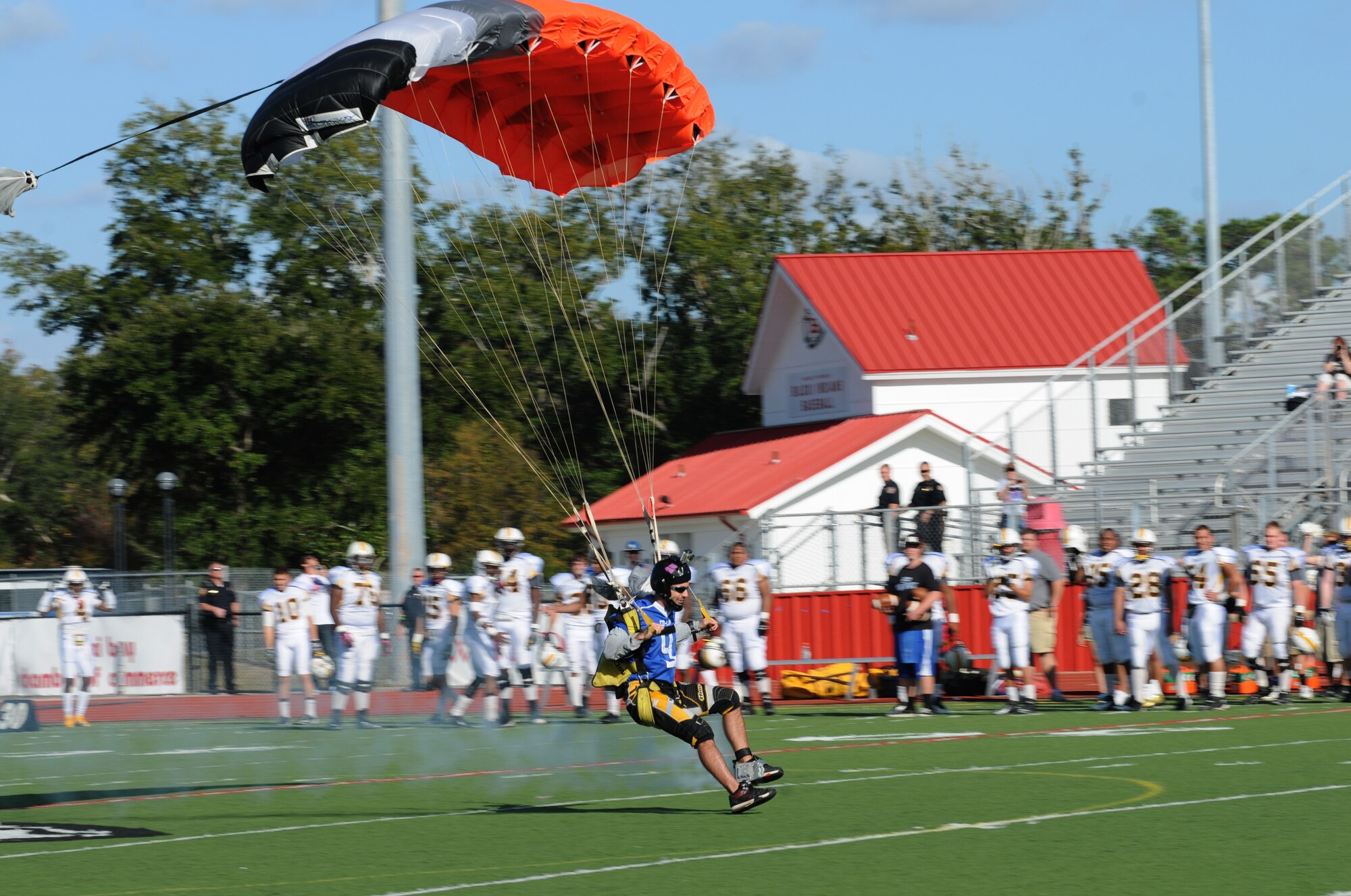 Craig Saucier, member of the All-American Skydiving Team, lands on the football field during the pre-game celebration at the 2012 Mississippi Bowl at the Biloxi High School football stadium Dec. 2, 2012. Participation from Keesler Air Force Base, Miss., included the 50-State Flag Team, the Honor Guard, a C-130J Hercules fly over by the 403rd Wing and a drill down performance by the 81st Training Group.  (U.S. Air Force photo by Kemberly Groue)