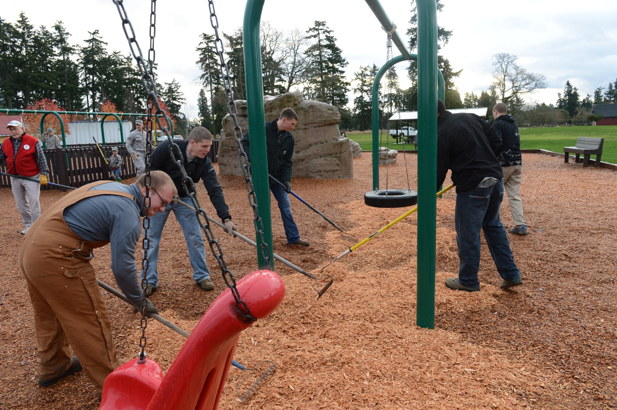 Airmen from the 62nd Airlift Wing, the 627th Air Base Group, and the Air Defense Sector, from Joint Base Lewis-McChord, Wash., use rakes to even out wood chips, Nov, 30, 2012, at Ft. Steilacoom Park in Lakewood, Wash. Approximately 30 Airman volunteered to work with members of the Lakewood Rotary Club to revitalize the playground. (U.S. Air Force photo/Staff Sgt. Sean Tobin)