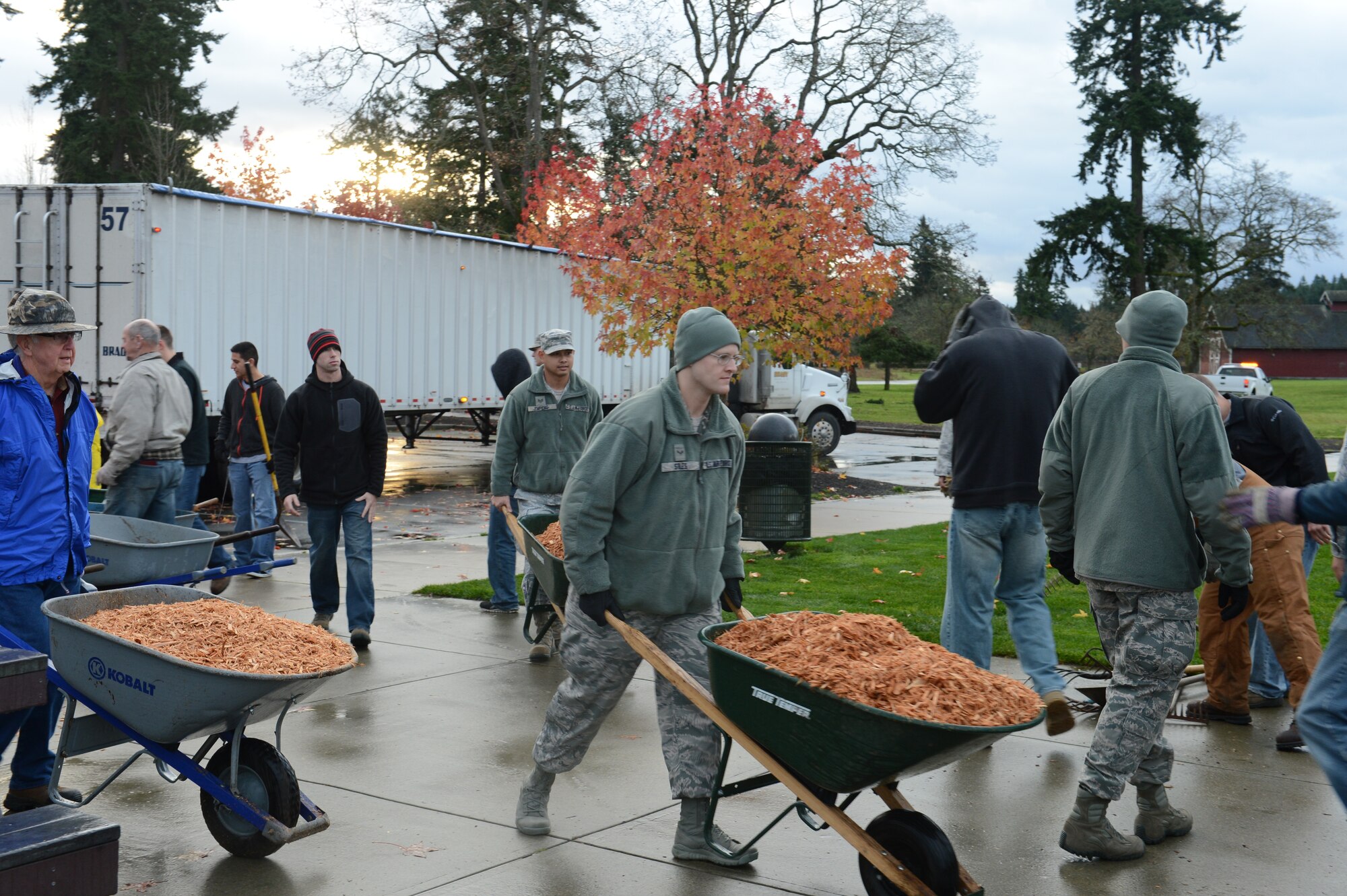 Airmen from the 62nd Airlift Wing, the 627th Air Base Group, and the Western Air Defense Sector, from Joint Base Lewis-McChord, Wash., along with members of the Rotary Club, transport wood chips to the playground, Nov. 30, 2012, at Ft. Steilacoom Park in Lakewood, Wash. The wood chips provide a soft cushion for the children using the jungle gym equipment. (U.S. Air Force photo/Staff Sgt. Sean Tobin)