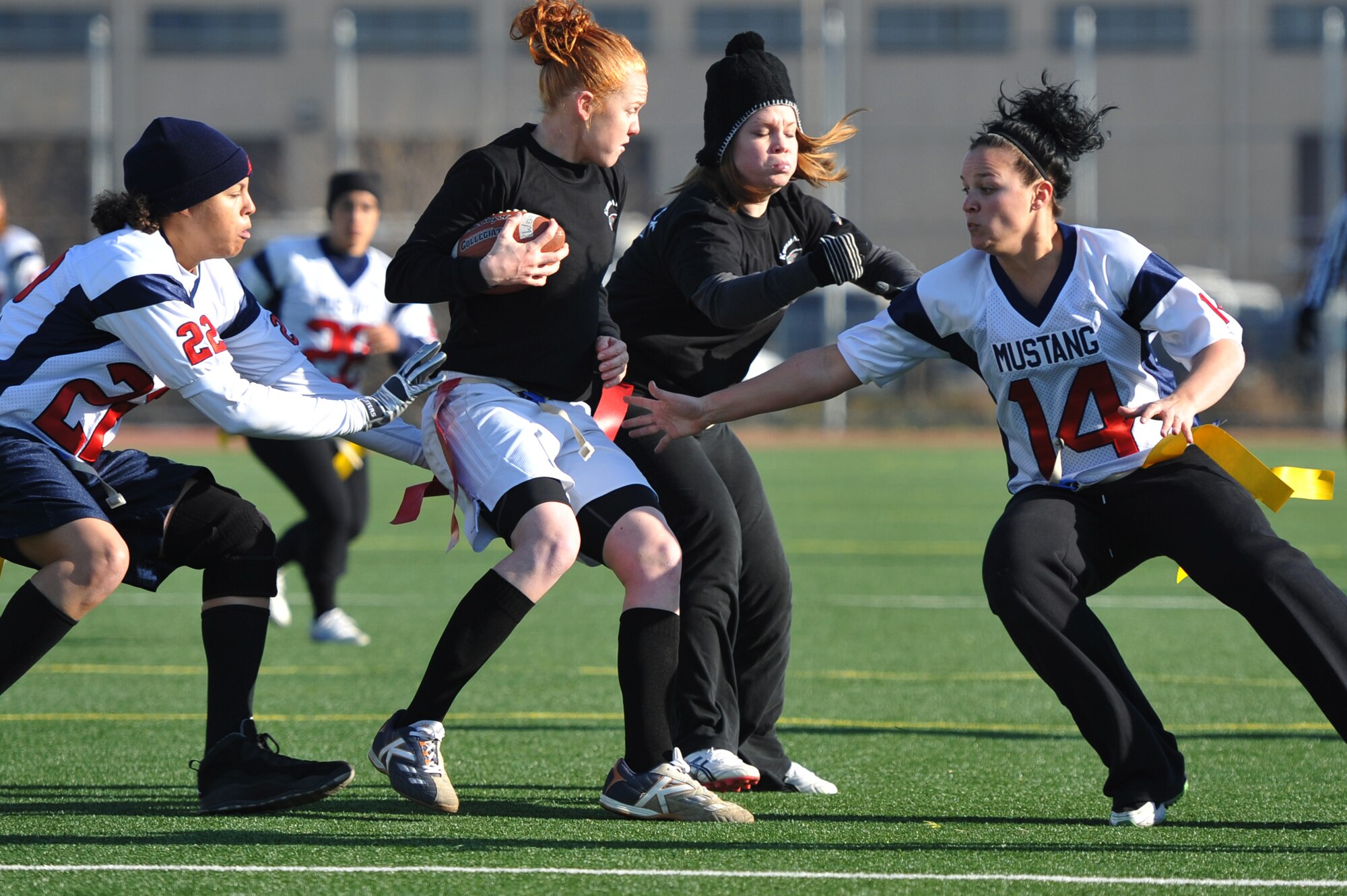Staff Sgt. April Walker (left) and Staff Sgt. Lynsey Bruzii (right), 51st Security Forces Squadron members, reach for Staff Sgt. Sahtara Wehe’s, 8th Maintenance Squadron member, flags in the powder-puff football game at Osan Air Base, Republic of Korea, Dec. 1, 2012. Mustangs lost their first game, but were victorious in game two with a score of 7 to 0. (U.S. Air Force photo/Staff Sgt. Craig Cisek)