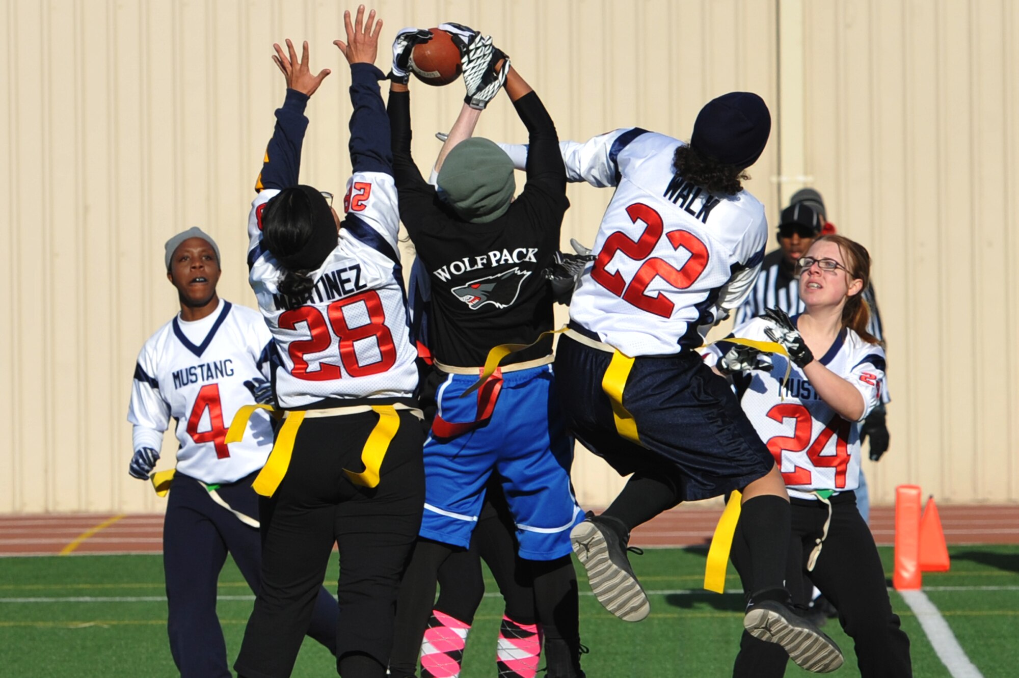 Airman 1st Class Khadija Price, 8th Security Forces Squadron member, snatches the football out of the air over Mustang defensive players during game one of the powder-puff game. The games were held Dec. 1, 2012, at Osan Air Base, Republic of Korea. (U.S. Air Force photo/Staff Sgt. Craig Cisek)