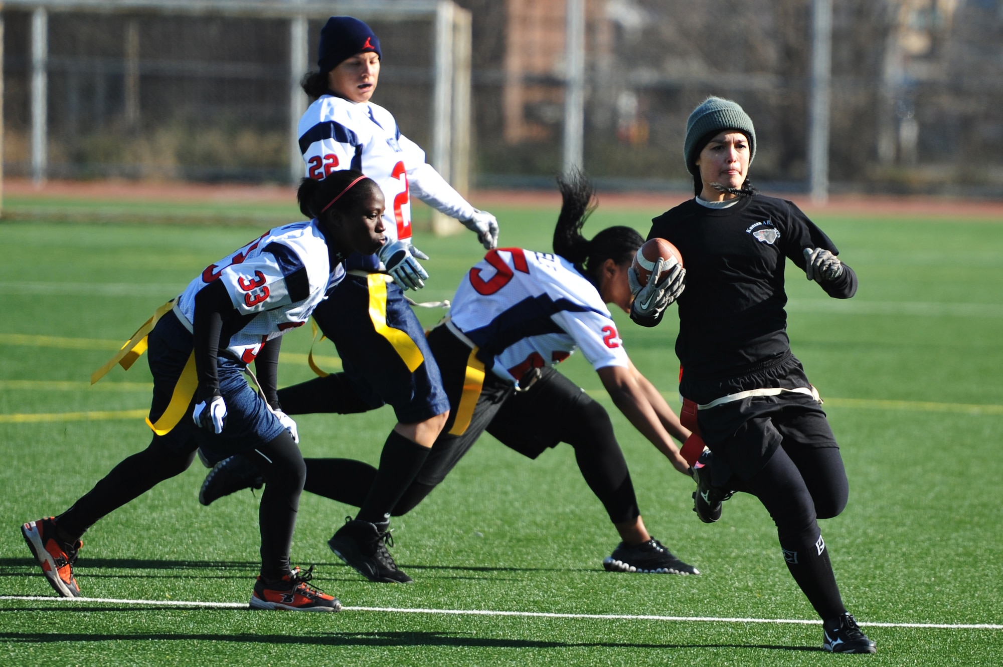 Staff Sgt. Joanne Schlieth (right), 8th Medical Operations Squadron member, sprints away from Mustang defenders in the powder-puff football game at Osan Air Base, Republic of Korea, Dec. 1, 2012. The Kunsan Wolfpack won their first game 16 to 7. (U.S. Air Force photo/Staff Sgt. Craig Cisek)