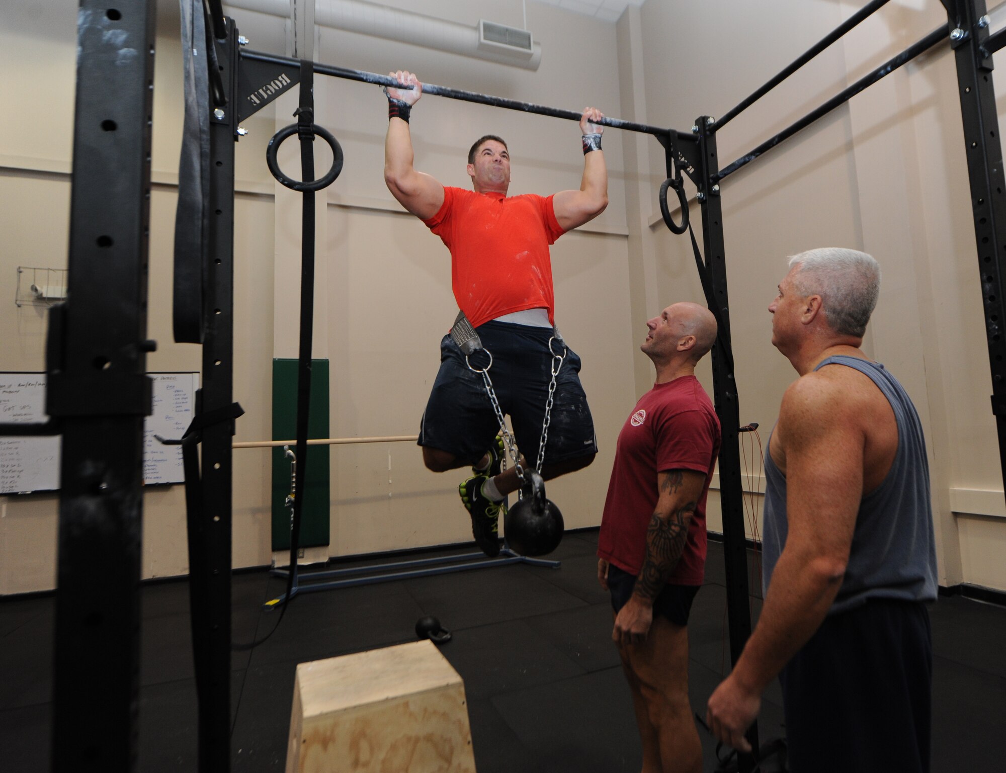 Tech. Sgt. Joshua Lemoine, 403rd Wing,does a pull-up with a kettle bell hanging from his waiste for more weight as Al Ciampa, 81st Aerospace Medicine Squadron exercise physiologist, and Major Shane Devlin, 53rd Weather Reconnaisance Squadron, stands by for support during a human performance course for physical training leaders Nov. 30, 2012 at the Dragon Fitness Center, Keesler Air Force Base, Miss. The human performance course is designed to teach physical training leaders proper movement to facilitate greater body mobility and stability, employing a whole-body approach to strength conditioning.  (U.S. Air Force photo by Kemberly Groue)