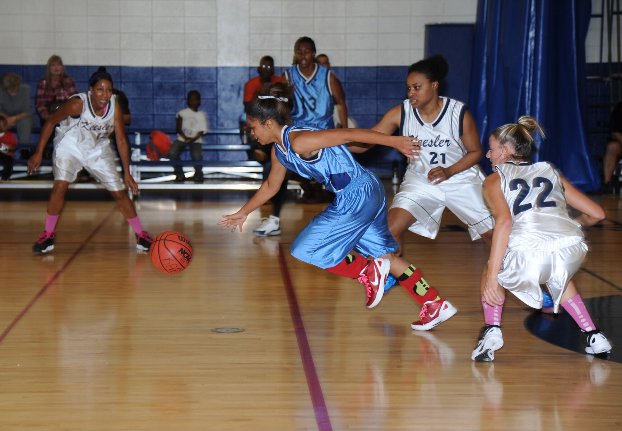 Kirsten Piernas, Keesler blue team, makes a fast break across half court as members from Keesler white team closes in on her during an inner-squad scrimmage among the women’s varsity basketball team Dec. 1, 2012, at the Blake Fitness Center, Keesler Air Force Base, Miss.  The Keesler white team defeated the Keesler blue team, 45-30.  (U.S. Air Force photo by Kemberly Groue)