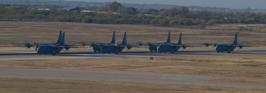Seven C-130Js prepare to take off during a training exercise Nov. 30, 2012, at Dyess Air Force Base, Texas. The C-130J incorporates state-of-the-art technology to reduce manpower requirements, lower operating and support costs, and provides life-cycle cost savings over earlier C-130 models. Compared to older C-130s, the J model climbs faster and higher, flies farther at a higher cruise speed, and takes off and lands in a shorter distance. Dyess has received 23 J models and is scheduled to get a total of 28, making it the largest C-130J unit in the world. (U.S. Air Force photo by Staff Sgt. Richard P. Ebensberger/ Released)