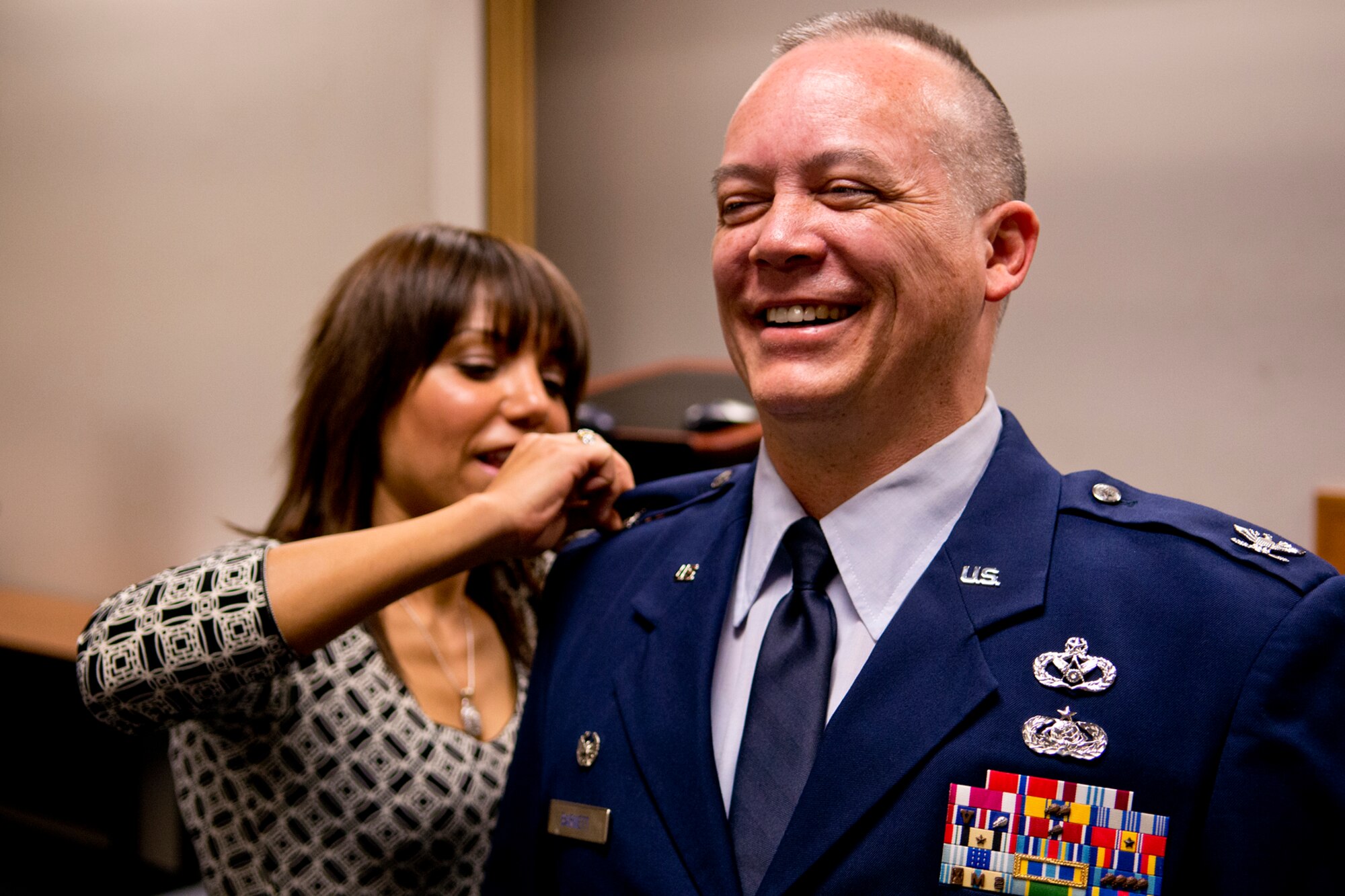 U.S. Air Force Col. Jeffery Barnett can’t help but laugh after seeing his colonel insignia was put on incorrectly during his Pinning On ceremony, Dec. 1, 2012, Barksdale Air Force Base, La. Barnett was pinned by his wife Nora and son Nathan during the ceremony. (U.S. Air Force photo by Master Sgt. Greg Steele/Released)