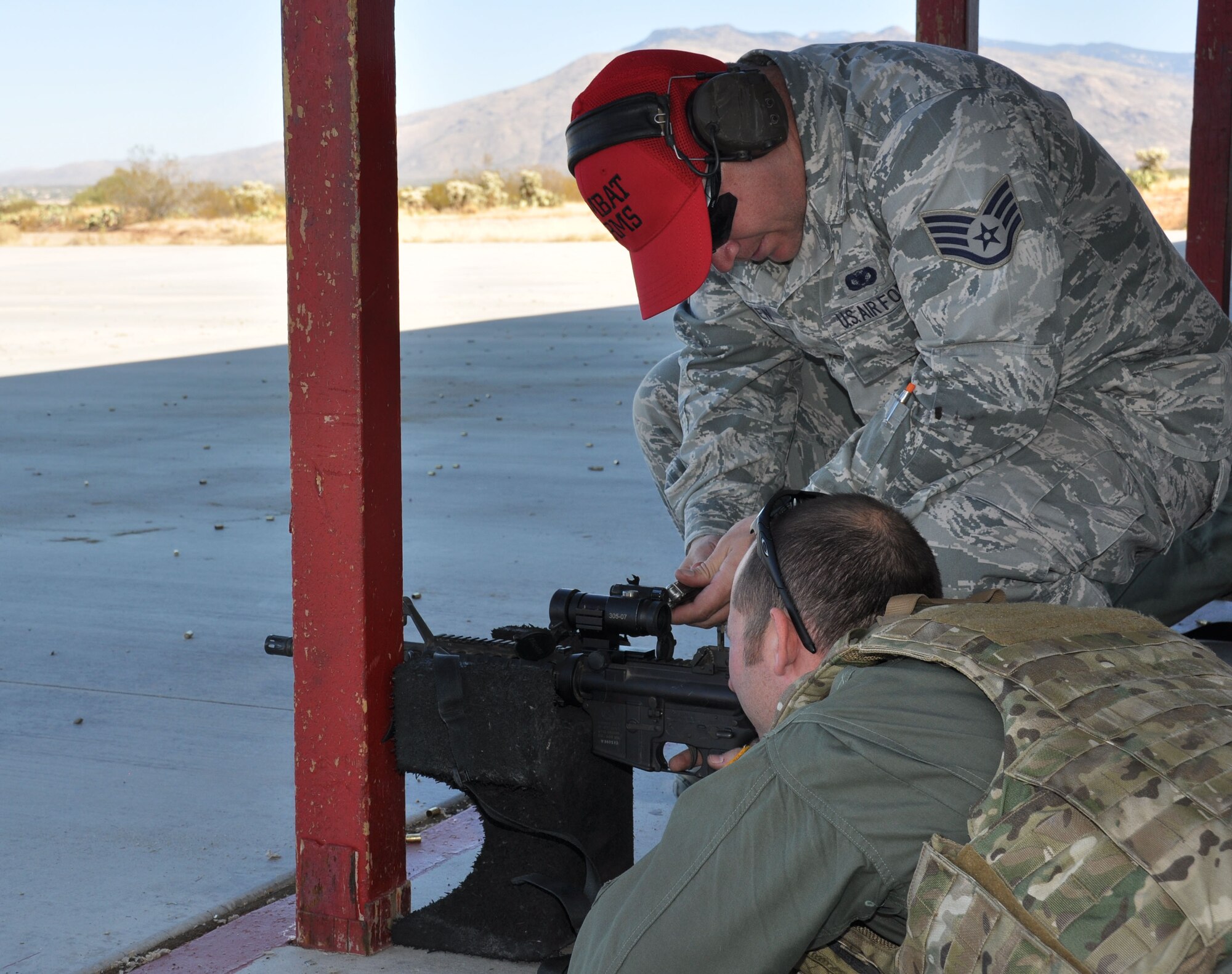 A combat arms instructor with the 943rd Rescue Group adjusts the sights on Maj. Nathan Horner’s M-4 rifle during a weapons qualification shoot. He is a 305th Rescue Squadron HH-60 Pave Hawk helicopter pilot. Aircrew from the 305th RQS participated in a weapons qualification shoot during the December Unit Training Assembly weekend. (U.S. Air Force Photo/ Staff Sgt. Sarah Pullen)  
