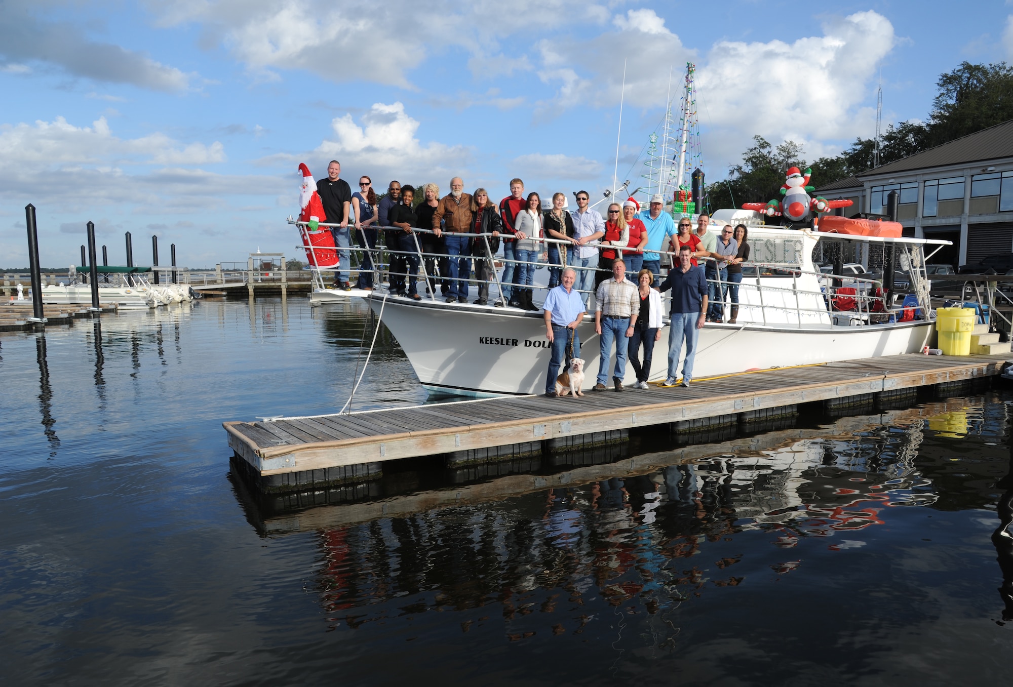 Personnel from Keesler Air Force Base, Miss., take a photo on the Keesler Dolphin II at the Marina Dec. 1, 2012, before departing to participate in the 27th Annual Christmas on the Water boat parade along the Mississippi Gulf Coast in Biloxi. Boats parade in full holiday décor with a fireworks show after the parade. The Dolphin, which was captained by Jim Young and Dave Bowers, was awarded third place in the commercial boats category.  Col. Rene Romero, 81st Training Wing vice commander, and retired Brig. Gen. Rich Moss, former 403rd Wing commander, participated as judges for the event.  (U.S. Air Force photo by Kemberly Groue)