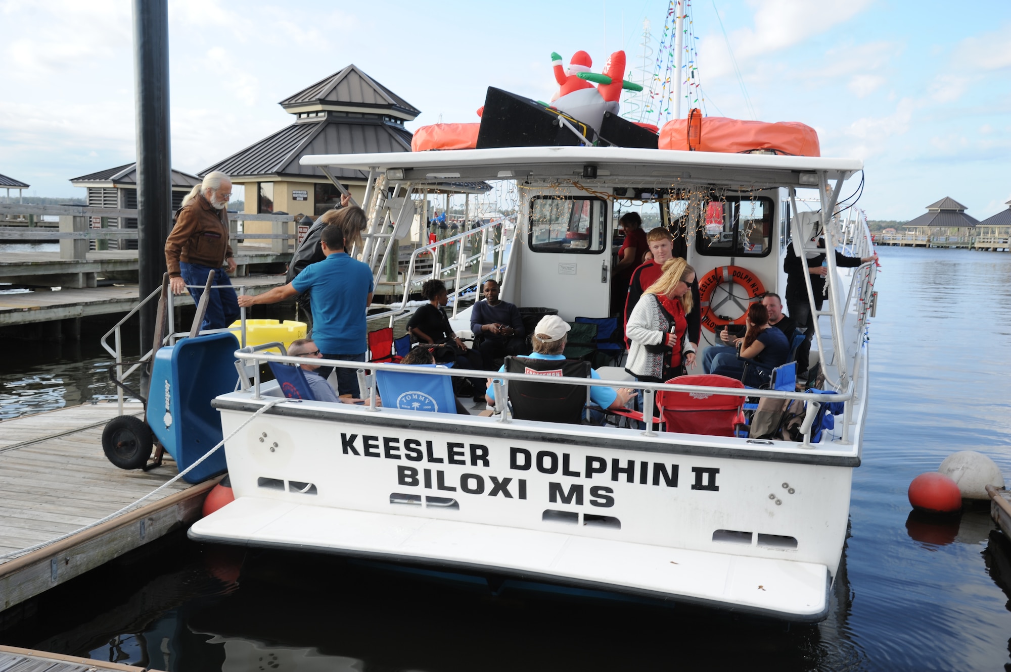 Personnel from Keesler Air Force Base, Miss., board the Keesler Dolphin II at the Marina Dec. 1, 2012, before departing to participate in the 27th Annual Christmas on the Water boat parade along the Mississippi Gulf Coast in Biloxi.  Boats parade in full holiday décor with a fireworks show after the parade. The Dolphin, which was captained by Jim Young and Dave Bowers, was awarded third place in the commercial boats category.  Col. Rene Romero, 81st Training Wing vice commander, and retired Brig. Gen. Rich Moss, former 403rd Wing commander, participated as judges for the event.  (U.S. Air Force photo by Kemberly Groue)