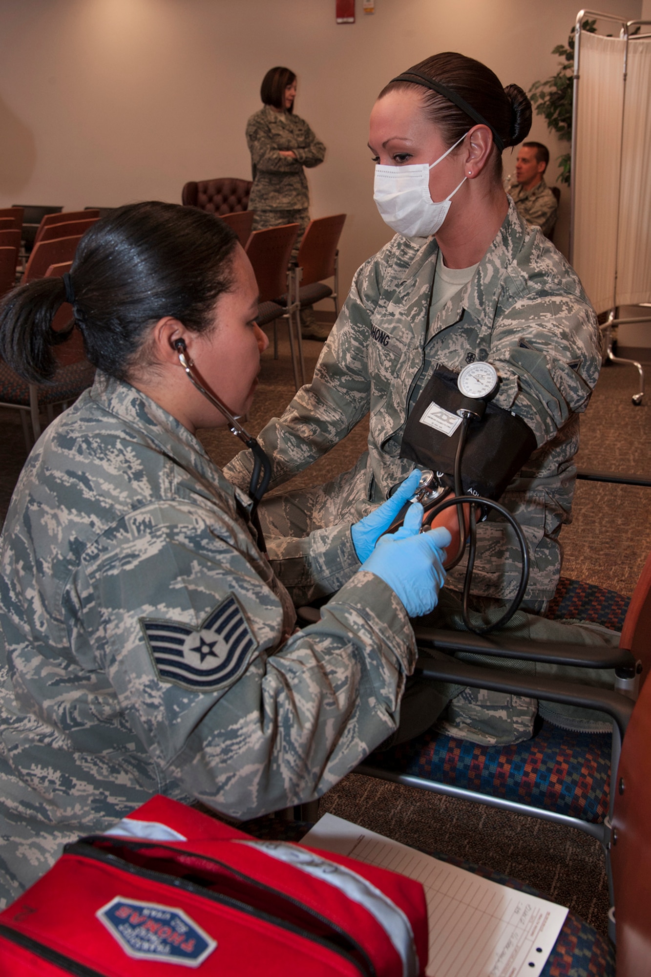 PETERSON AIR FORCE BASE, Colo. – Tech. Sgt. Tonya Patton, 21st Aerospace Medicine Squadron Clinical treatment team, performs a blood pressure check on Airman 1st Class Rachel Bushong, 21st AMDS. The check was part of a 21st Medical Group triage exercise Nov. 27 in Hangar 123, and provided 21st MDG personnel readiness training in the event of a real-world incident. (U.S. Air Force photo/Craig Denton)