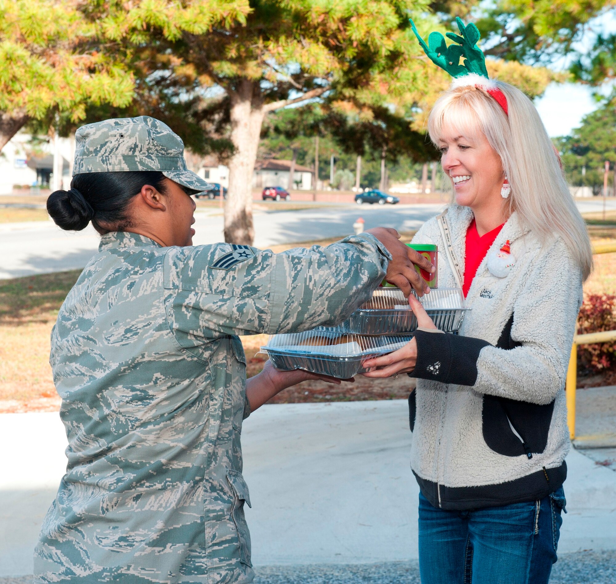 Senior Airman Evelyn Velasquez, 325th Medical Support Squadron pharmacy technician, dropped off cookies with Mrs. Sunny Stumpe, wife of Lt. Col. Brian Stumpe, 325th Civil Engineer Squadron commander, for the 2012 Cookie Caper Dec. 3. The Cookie Caper is an annual program designed to deliver cookies to Airmen living in the dormitories.  (U.S. Air Force photo by Christopher Cokeing)