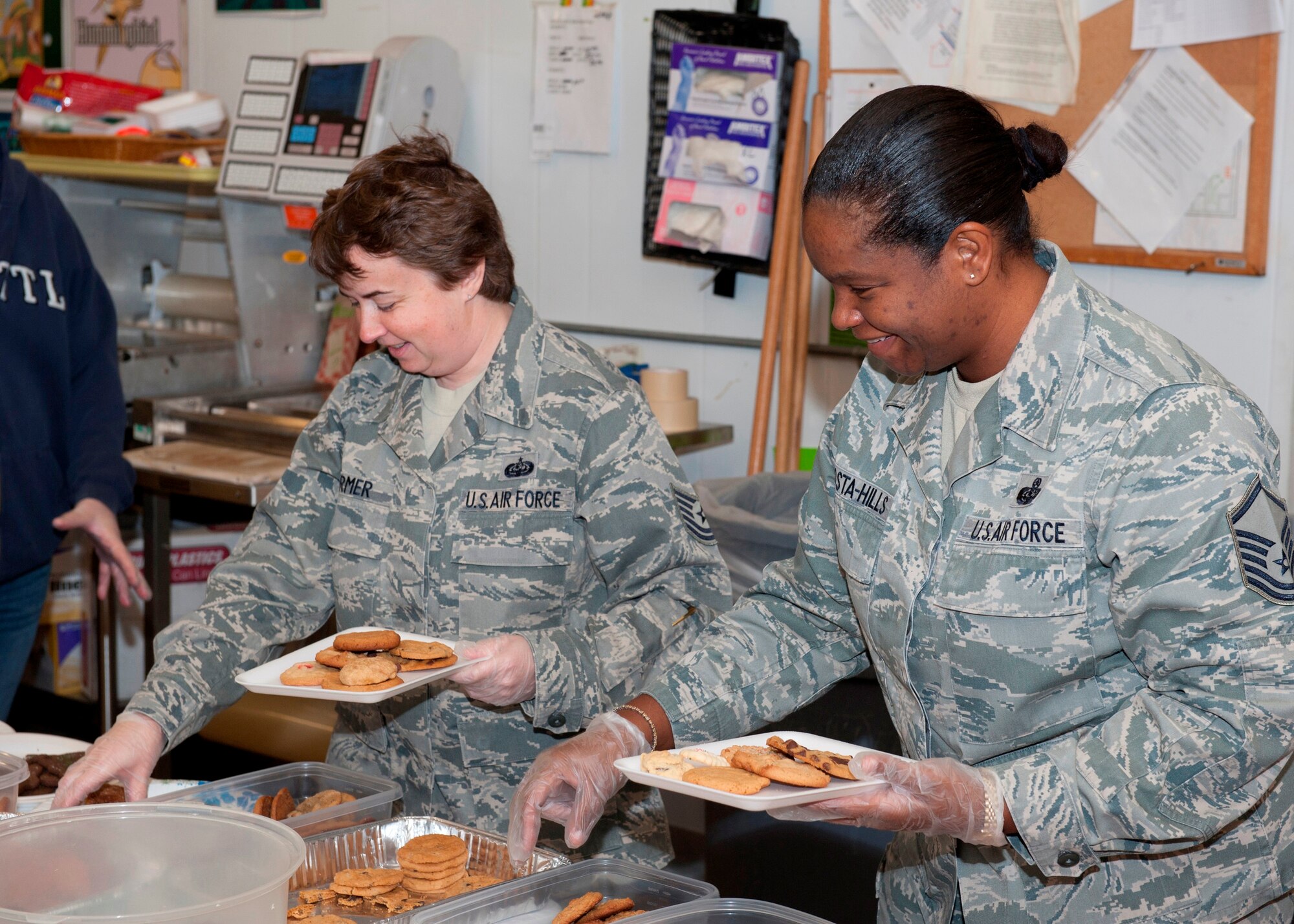 Tech. Sgt. Elizabeth Farmer, 325th Communications Squadron client systems technician, and Master Sgt. Tanya DaCosta-Hills, 325th CS section chief of client systems, packaged cookies for the 2012 Cookie Caper Dec. 3. The Cookie Caper is an annual program designed to deliver cookies to Airmen living in the dormitories. (U.S. Air Force photo by Christopher Cokeing)