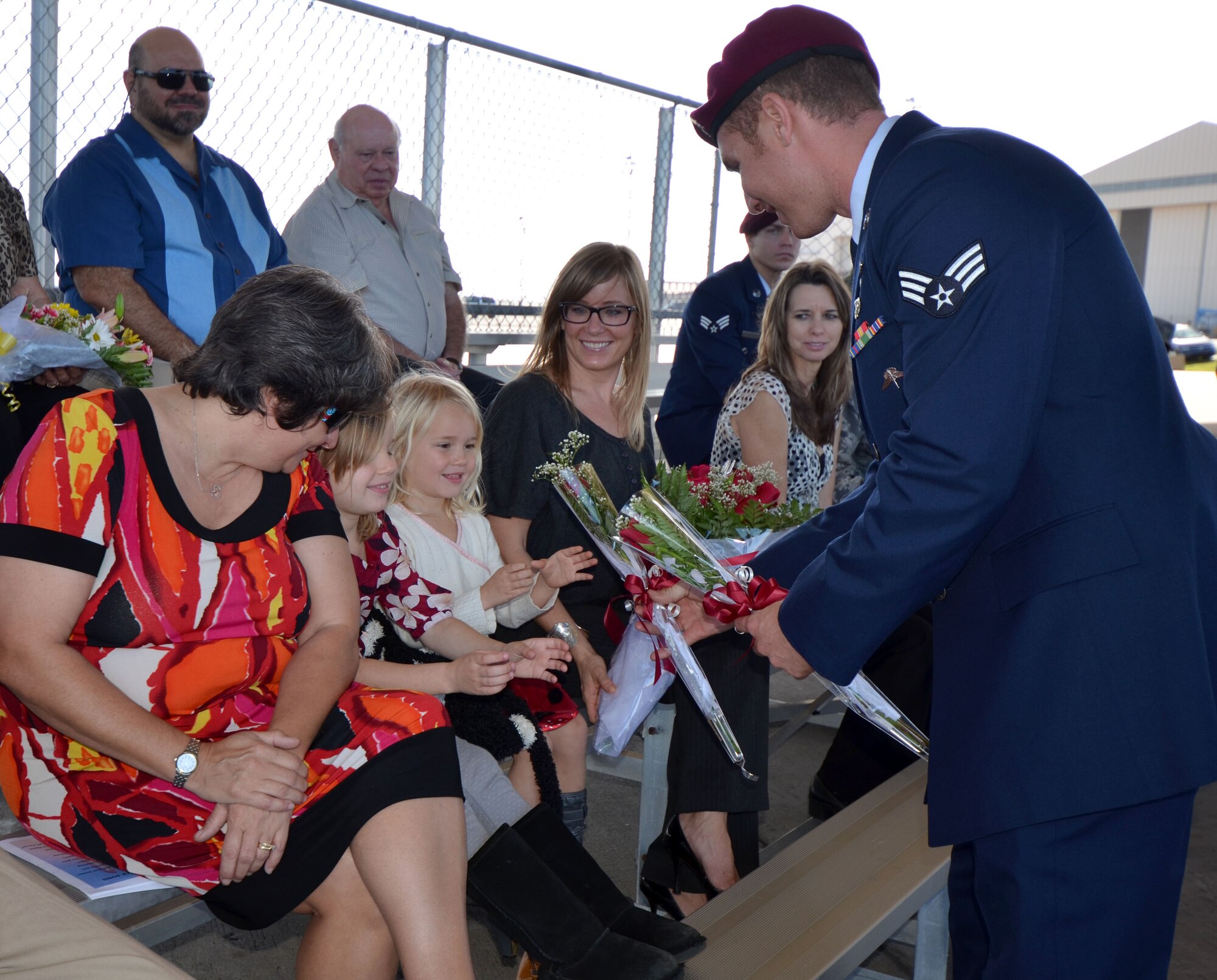 Senior Airman Carl Enis, 308th Rescue Squadron pararescueman, hands flowers to the wife and children of Maj. John Fish, who assumed command of the 308th RQS from Lt. Col. Kurt Matthews Sunday during the 920th Rescue Wing's Unit Training Assembly. The 308th RQS falls under the 920th RQW which is an Air Force Reserve combat search and rescue unit dedicated to rescuing downed service members behind enemy lines as well as providing rescue support to civilians in distress. (U.S. Air Force photo/2nd Lt. Leslie Forshaw)