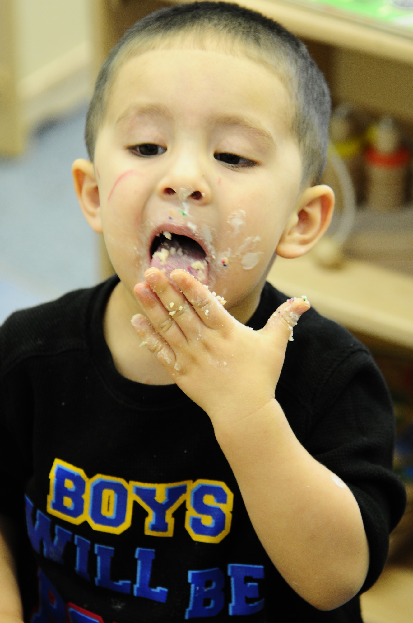 Anthony Norat, son of Sgt. Abby Norat, 5th Quarter Master, licks his fingers after decorating his cookie at the Child Development Center during a cookie decorating project for wounded warriors at the Contingency Aeromedical Staging Facility on Ramstein Air Base, Germany, Nov. 30, 2012. The CDC directors and Parental Advisory Board made the decision to do this with the classrooms to get into the holiday spirit and teach the children about giving to others. (U.S. Air Force photo/Airman 1st Class Hailey Haux)
