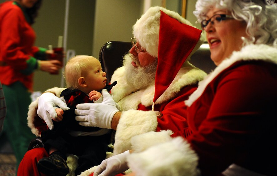 One-year-old Oscar Clausen, son of LeAnn Clausen, 55th Force Support Squadron’s Outdoor Recreation director, gets a chance to meet Santa and Mrs. Claus while attending the Christmas Tree Lighting Ceremony held at both the Strategic Air Command Chapel and the Patriot Club at Offutt Air Force Base, Neb., Nov. 29.  The Patriot Club offered numerous family activities and food.  (U.S. Air Force photo by Josh Plueger/Released)