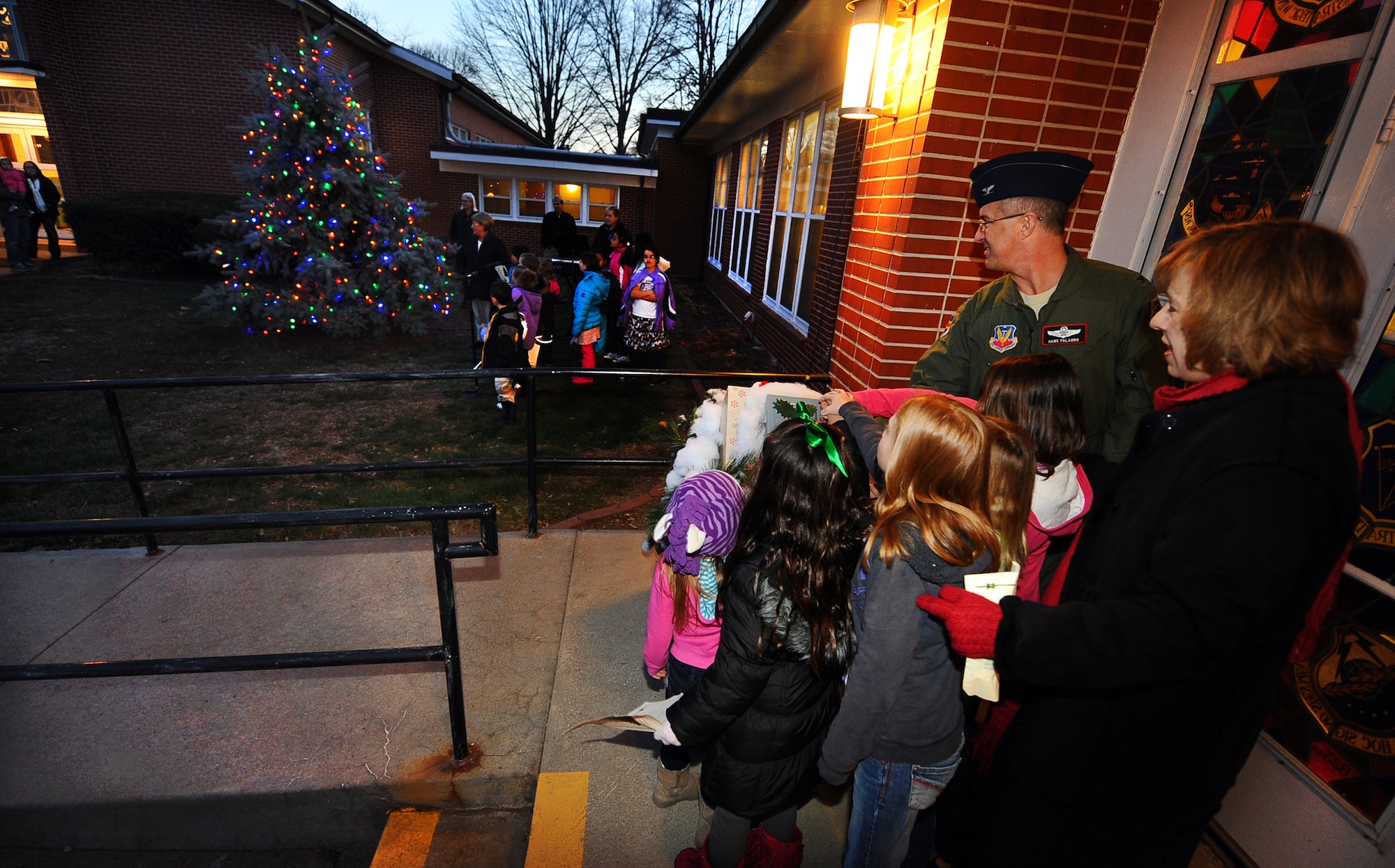 U.S. Air Force Col. Hans Palaoro, 55th Wing vice commander, with the help of 55th Aircraft Maintenance Squadron’s Staff Sgt.’s Mark Lewis’s children, flips the switch to illuminate Strategic Air Command Chapel’s Christmas Tree at Offutt Air Force Base, Neb., Nov. 29.  Every year hundreds of families gather at the SAC Chapel to attend the Christmas Tree Lighting prior to going indoors for food, games and a chance to meet Santa Claus.  (U.S. Air Force photo by Josh Plueger/Released)