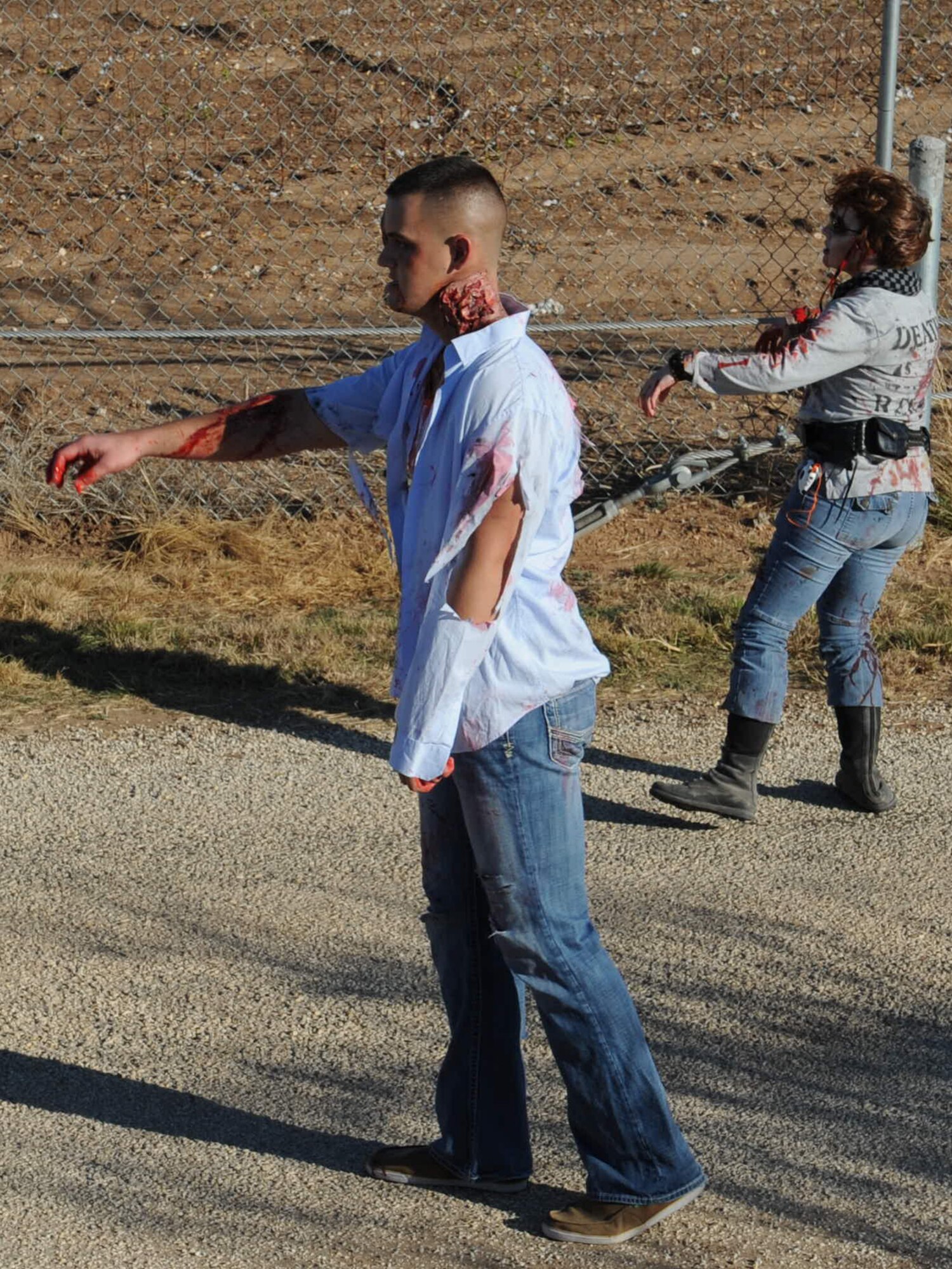 U.S. Marine Corps Lance Cpl. Zack Moore, Marine Corps Detachment (MCD) Goodfellow, and U.S. Air Force Staff Sgt. Kelly Mascharka, 315th Training Squadron instructor, shamble towards runners during the 1st ever Zombie Run at Goodfellow Air Force Base, Texas, Dec. 1, 2012. (U.S. Air Force photo by Staff Sgt. Laura R. McFarlane)  