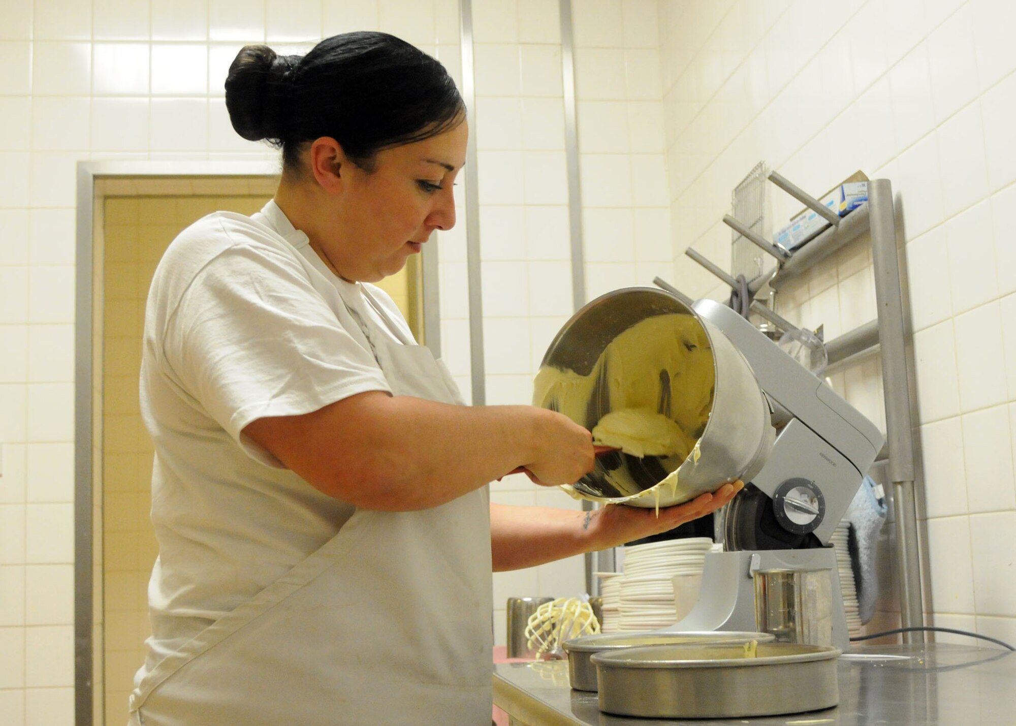 Roz Rooney, 100th Force Support Squadron baker from Dublin, Ireland, prepares a cake for the next day’s lunch at the Gateway Dining Facility, Dec. 3, 2012, at RAF Mildenhall, England. The cakes at the DFAC are generally made a day in advance so they are cool and ready to be finished with icing the next morning. (U.S. Air Force photo by Airman 1st Class Kelsey Waters/Released)