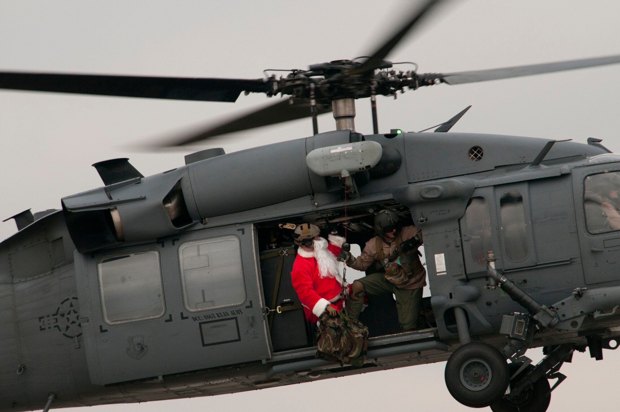 ROYAL AIR FORCE LAKENHEATH, England - Tech. Sgt. Mike Morrison, 56th Rescue Squadron NCO in charge of standards and evaluations and native of Salisbury, Mo., prepares Santa Claus, a North Pole native, to be lowered to the ground from an HH-60G Pave Hawk Dec. 1, 2012. Claus teamed up with the 56th RQS to bring Christmas cheer to Team Lakenheath members. After being dropped off, Claus proceeded to Hangar 7 where children were able to meet him and tell him what they wanted for Christmas. (U.S. Air Force photo by Staff Sgt. Stephen Linch)