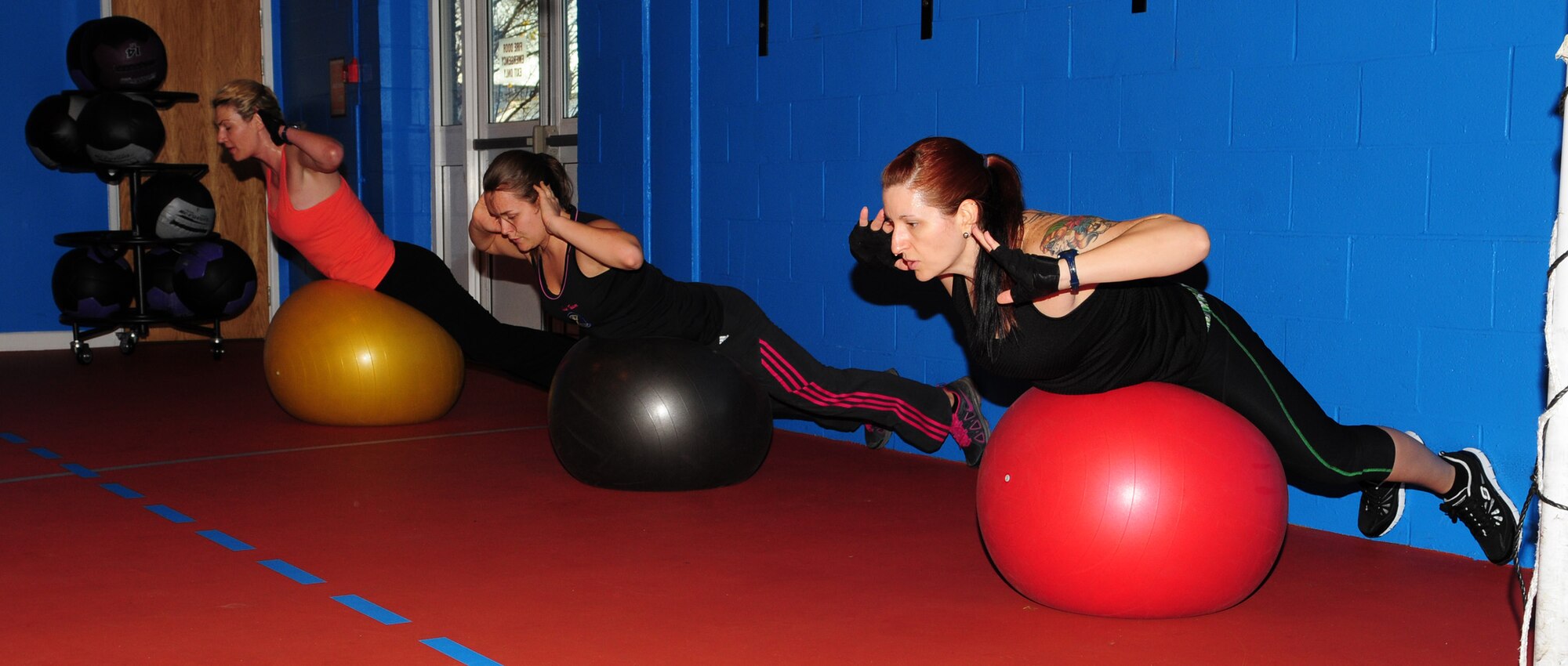 From left, Shana Williams, 100th Security Forces Squadron spouse; Pamela Walker, 321st Special Tactics Squadron spouse; and instructor Brandy Willaman, 48th Component Repair Squadron spouse, perform exercises on fitness balls Nov. 30, 2012, at the North Side Fitness Center, RAF Mildenhall, England. The one-hour class, held Mondays, Wednesdays and Fridays at 9:30 a.m., is one of many offered at the fitness centers on base. (U.S. Air Force photo by Karen Abeyasekere)