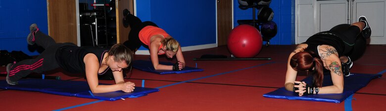From left, Pamela Walker, 321st Special Tactics Squadron spouse from Albuquerque, N.M.; Shana Williams, 100th Security Forces Squadron spouse from Visalia, Calif.; and instructor Brandy Willaman, 48th Component Maintenance Squadron spouse, perform a plank with raised leg exercise at the “legs, bums and tums” class Nov. 30, 2012, at the North Side Fitness Center, RAF Mildenhall, England. Both the North Side Fitness Center and Hardstand Fitness Center offer a range of fitness classes: combat circuit, cardio kick, core stability, yoga and pilates, spinning, and legs, bums and tums. For more information, call the North Side Fitness Center at 01638 542349 or the Hardstand Fitness Center at 01638-543735. (U.S. Air Force photo by Karen Abeyasekere/Released)