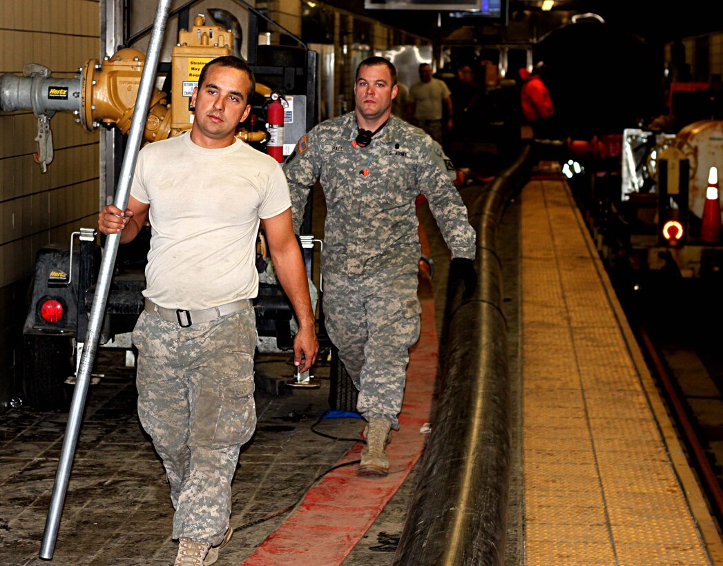 U.S. Army Spc. Bradley Zemen, left, and Sgt. Britton Hall, both attached the Special Troops Battalion, 7th Sustainment Brigade, Fort Eustis, Va., help the New Jersey and New York Fire Department pump out water from the Port Authority Trans-Hudson Exchange Place Station, in Jersey City, N.J., Nov. 9, 2012. The subway system was flooded all the way to the World Trade Center Station from the damage left by Hurricane Sandy. (U.S. Army photo by Capt. Nathan Brenan/Released)