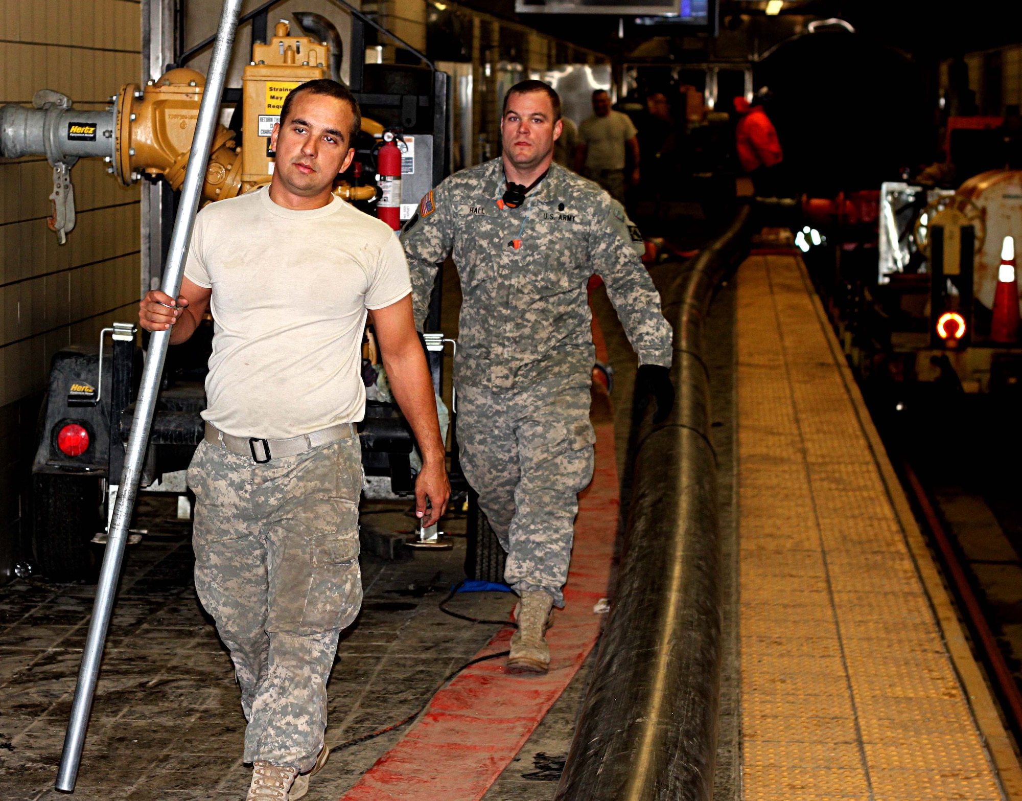 U.S. Army Spc. Bradley Zemen, left, and Sgt. Britton Hall, both attached the Special Troops Battalion, 7th Sustainment Brigade, Fort Eustis, Va., help the New Jersey and New York Fire Department pump out water from the Port Authority Trans-Hudson Exchange Place Station, in Jersey City, N.J., Nov. 9, 2012. The subway system was flooded all the way to the World Trade Center Station from the damage left by Hurricane Sandy. (U.S. Army photo by Capt. Nathan Brenan/Released)