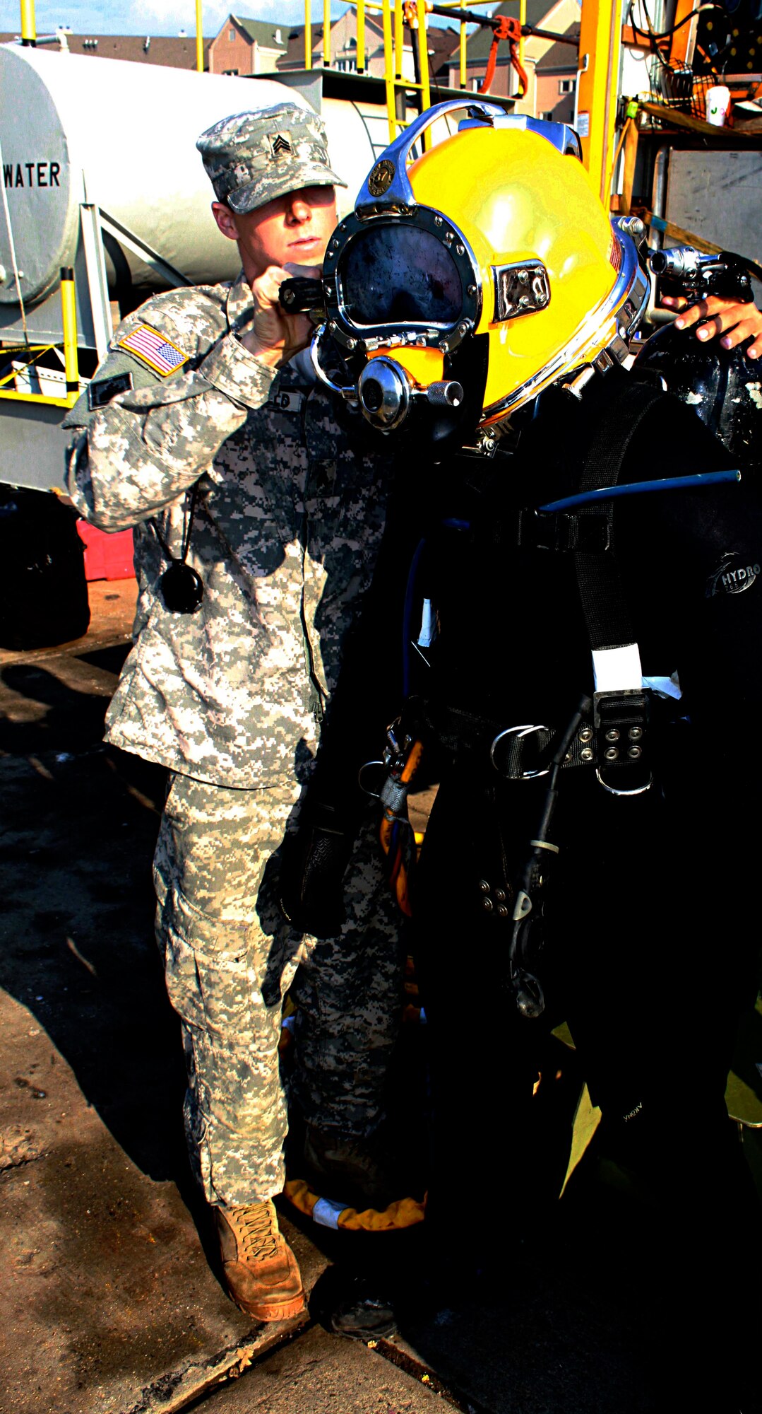 U.S. Army Pfc. Jacob Feyers, a diver tender attached to the Special Troops Battalion, 7th Sustainment Brigade, Fort Eustis, Va., dons his diving suit, with help from Sgt. Sky Schofield, before entering in the Lower Hudson Bay to inspect the US Army Corps of Engineers Caven Point Marine Terminal pier, Jersey City, N.J., Nov. 11, 2012. Feyers is part of a team of divers attached to the STB that assisted the New York Metropolitan area after the damage left by Hurricane Sandy. (U.S. Army photo by Capt. Nathan Brenan/Released)