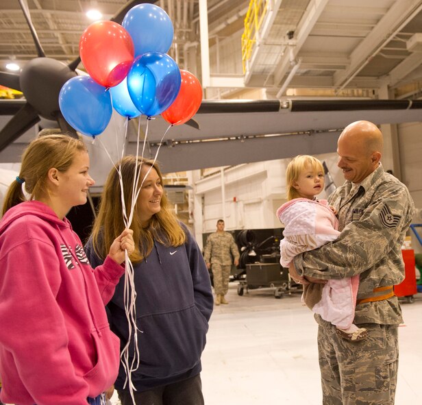 Air National Guard Tech. Sgt. Sean Cummings, 116th Aircraft Maintenance Squadron, and his family are all smiles upon his return from a deployment in the early morning hours of Dec. 3 at Robins Air Force Base, Ga.  Approximately 50 Team JSTARS operations, maintenance and support personnel were returning home from a three month deployment to an undisclosed location in the Middle East. (National Guard photo by Master Sgt. Roger Parsons/Released)

