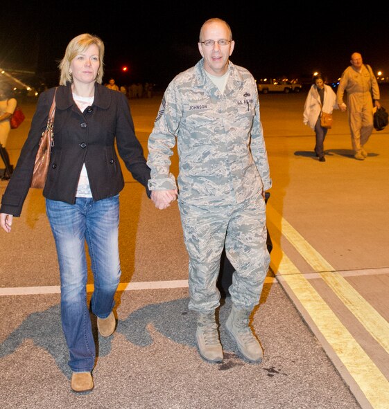 Georgia Air National Guard members from the Team JSTARS 116th Air Control Wing, walk hand in hand with their wives upon their return from a deployment in the early morning hours of Dec. 3 at Robins Air Force Base, Ga.  Approximately 50 Team JSTARS operations, maintenance and support personnel were returning home from a three month deployment to an undisclosed location in the Middle East. (National Guard photo by Master Sgt. Roger Parsons/Released)