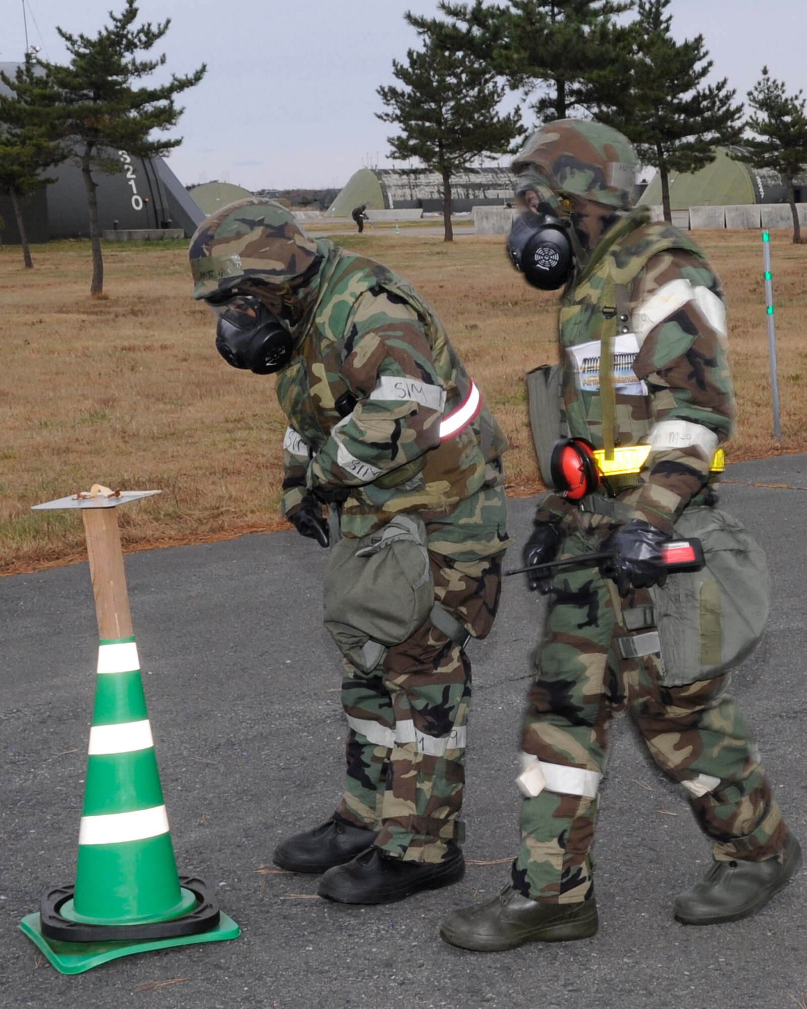 U.S. Air Force Airman 1st Class Estefani Santana, 35th Aircraft Maintenance Squadron weapons loader, and Airman 1st Class Sean Williams, 35th Maintenance Squadron crew chief, simulate a post-attack reconnaissance sweep during an Operational Readiness Exercise at Misawa Air Base, Japan, Dec. 3, 2012. Airmen must look for unexploded ordnances, hazards and traces of contamination following an attack. (U.S. Air Force photo by Airman 1st Class Kaleb Snay) 