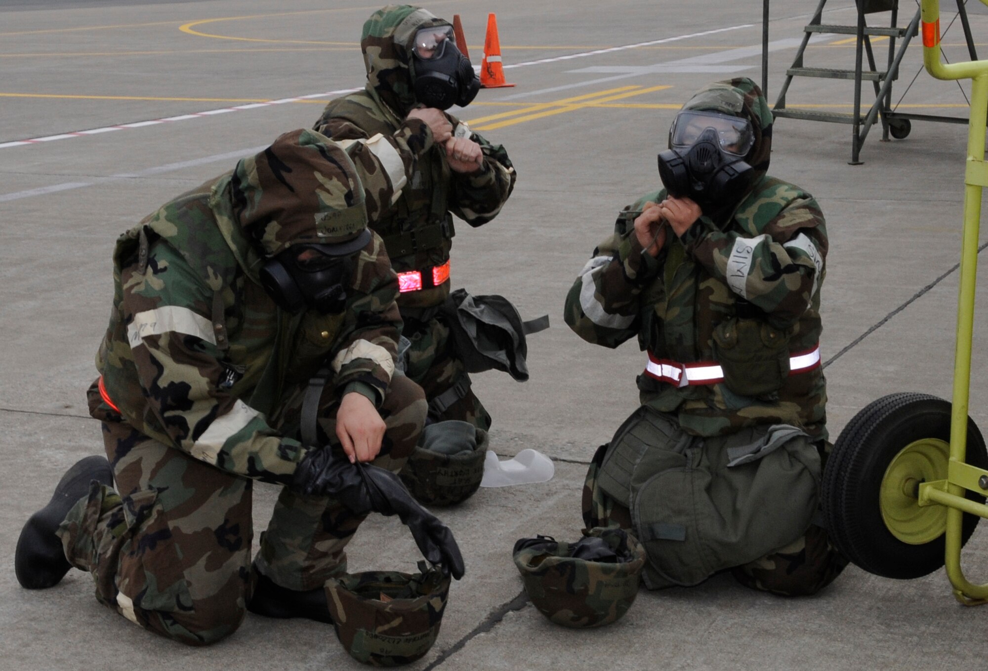 U.S. Air Force Airman 1st Class Jonathan Elizondo (left), Staff Sgt. Ryan Worthy (center), and Airman 1st Class Estefani Santana (right), 35th Aircraft Maintenance Squadron weapons loaders, don their Mission Oriented Protective Posture gear during an operational readiness exercise at Misawa Air Base, Japan, Dec. 3, 2012. MOPP gear is used to protect Airmen against chemical, biological, radiological and nuclear attacks and is worn during the course of the exercise. (U.S. Air Force photo by Airman 1st Class Kaleb Snay)