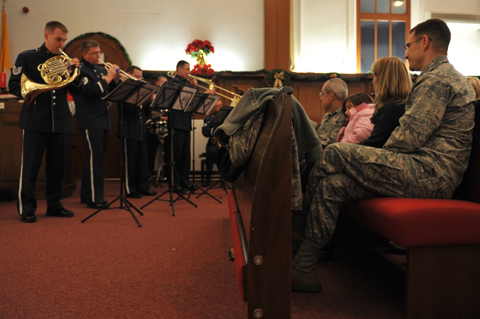 Brig. Gen. C.K. Hyde, 86th Airlift Wing commander, Jodie Hyde, wife of Brig. Gen. C.K. Hyde, 86th Airlift Wing commander, and Chief Master Sgt. James Morris, 86th Airlift Wing command chief, enjoy music played by the U.S. Air Forces in Europe Five Star Brass band at the Vogelweh Chapel on Kapaun Air Station, Germany, Nov. 29, 2012. The tree lighting was used to kick off the Christmas holiday season. (U.S. Air Force photo/Airman 1st Class Holly Cook)