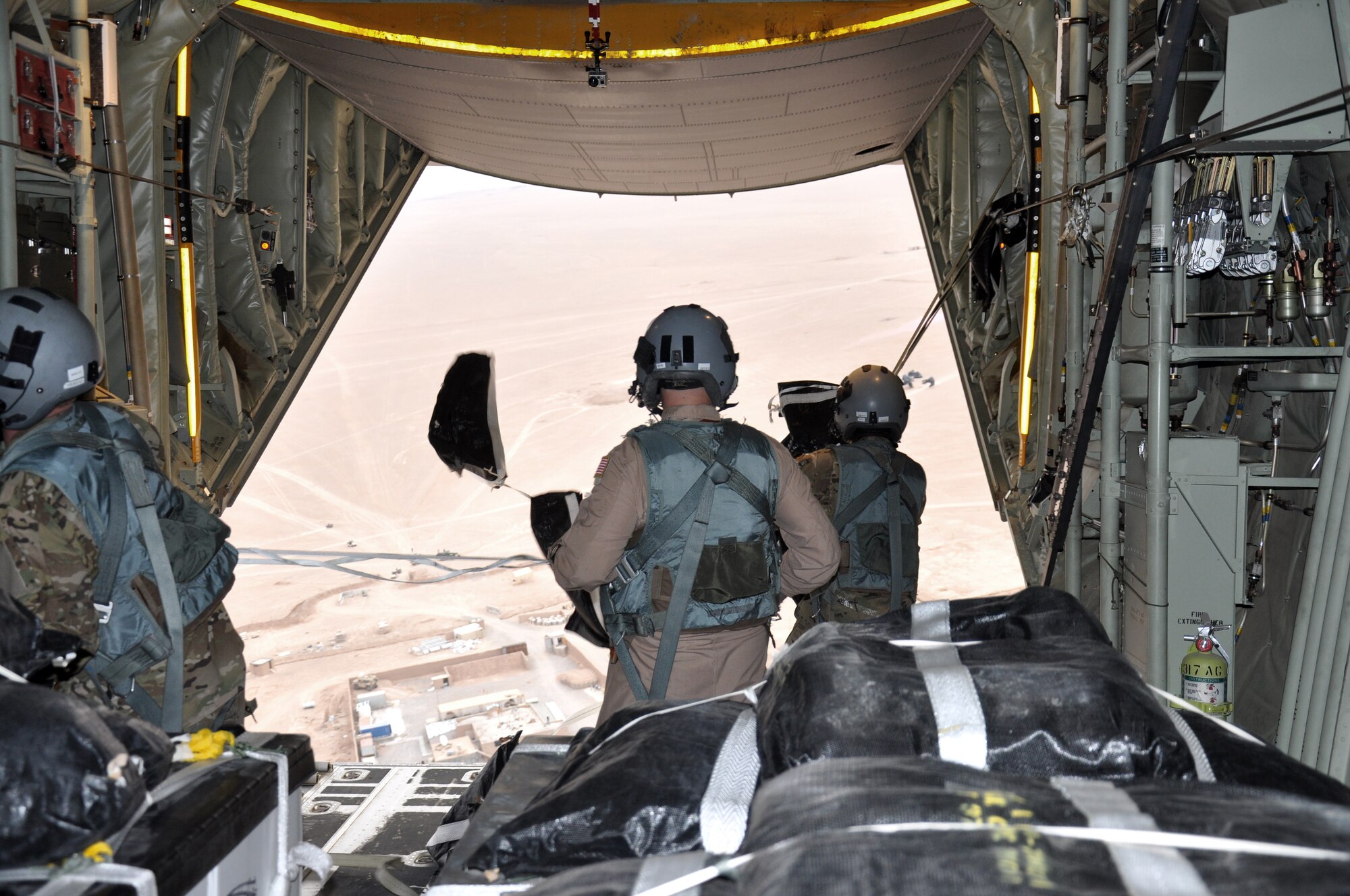 Senior Airman Dan Simonsen, Senior Master Sgt. Steve Martin and Senior Airman Marcus Wright, loadmasters with the 772nd Expeditionary Airlift Squadron, perform a Low Cost Low Altitude airdrop from the back of a C-130J in southwest Afghanistan Nov. 15. They are deployed from Dyess Air Force Base, Texas. (U.S. Air Force photo/Capt. Tristan Hinderliter)