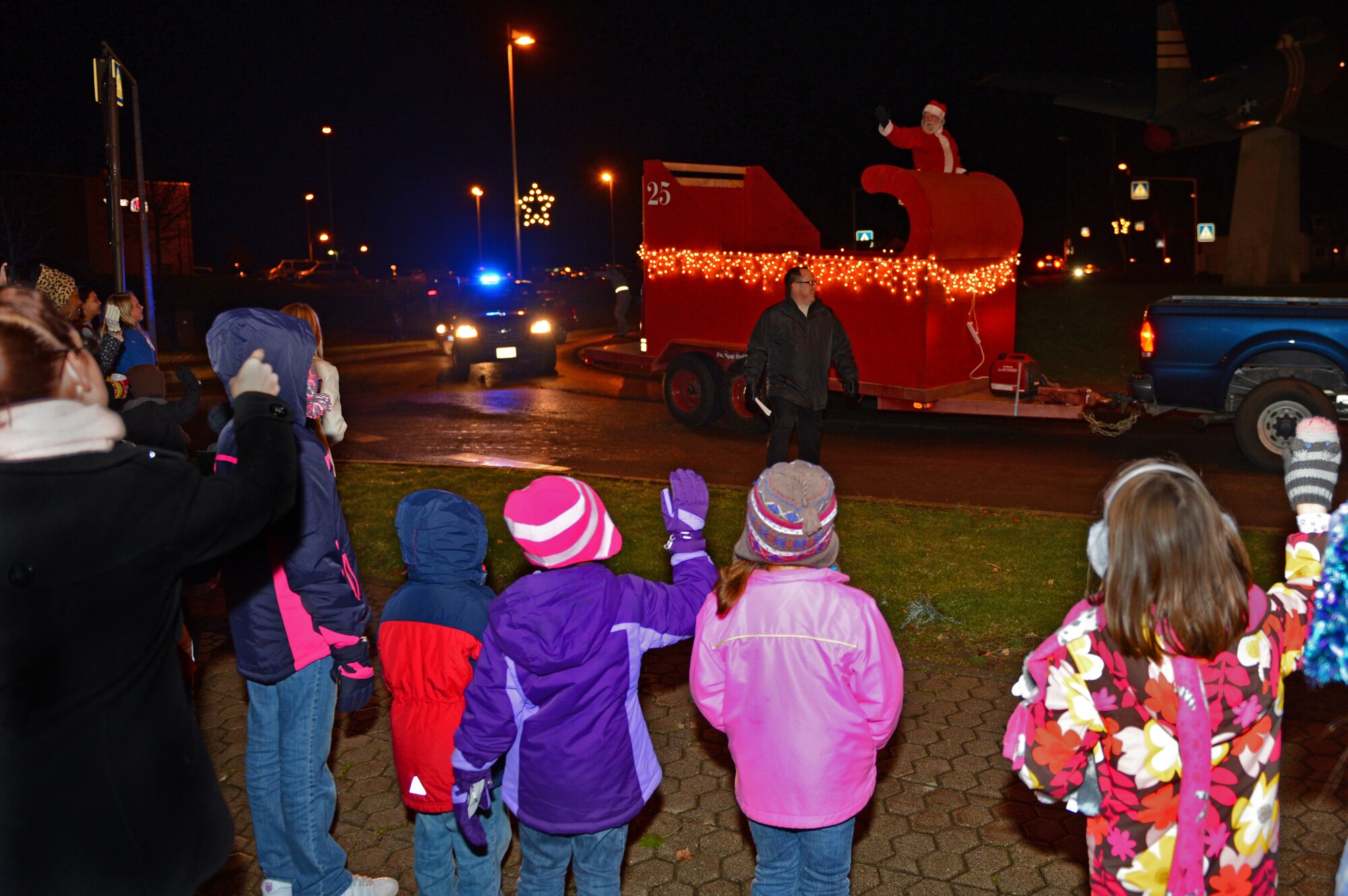 SPANGDAHLEM AIR BASE, Germany – Children wave as Santa rides past in a parade float during the Holiday Tree Lighting Ceremony Nov. 29, 2012. Santa also enjoyed snacks and beverages with family members after the ceremony to spread holiday cheer. The event brought members of the community together to get into the holiday spirit while strengthening local partnerships. (U.S. Air Force photo by Airman 1st Class Dillon Davis/Released)
