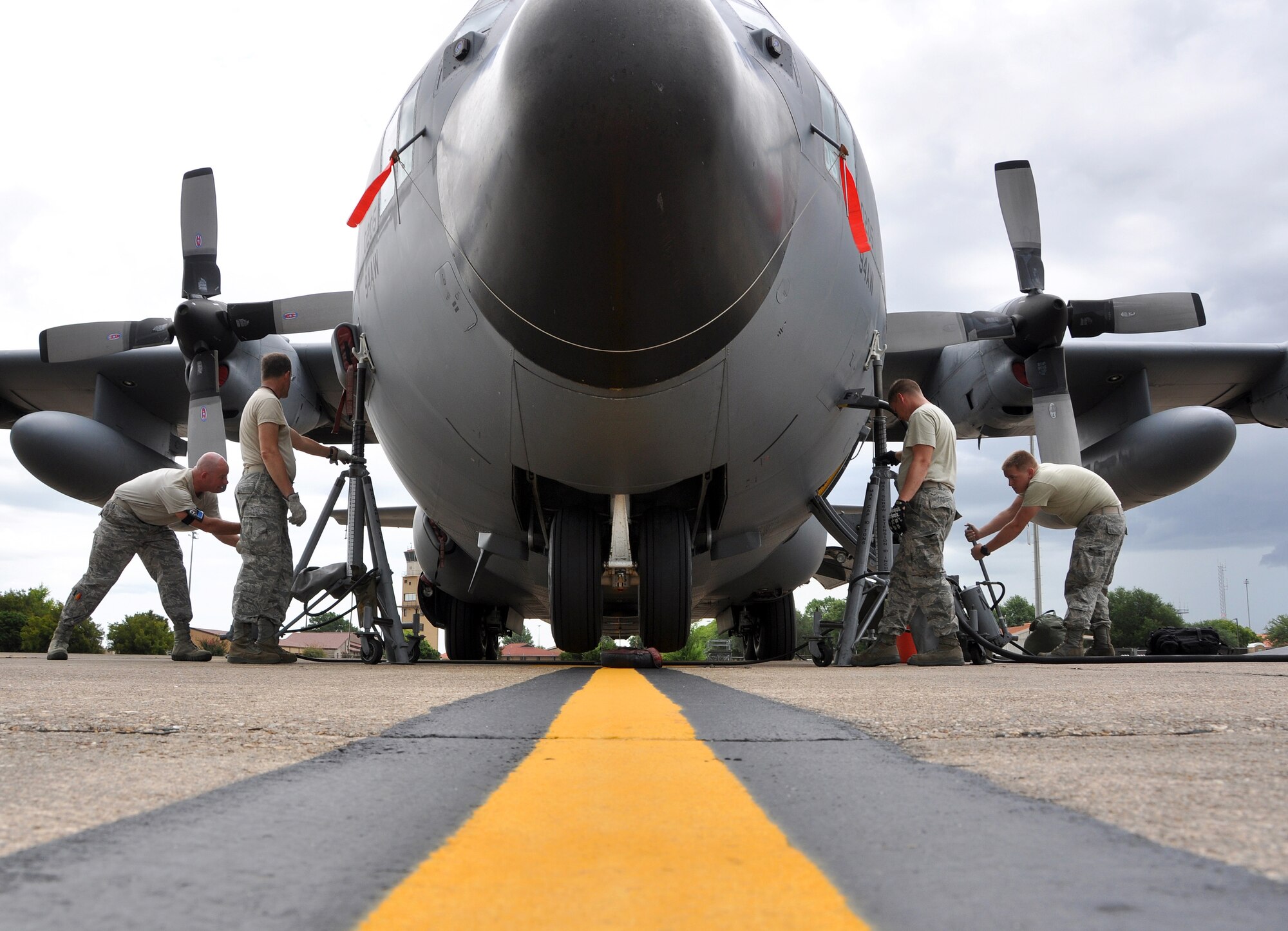 Members of the 94th Airlift Wing lift a C-130 Hercules using specialized jack stands to work on the front landing gear at Maxwell Air Force Base on July 10. Members of the 94th AW were relocated from Dobbins ARB to Maxwell AFB as part of a mini deployment so that they could continue to train and remain combat ready during the Dobbins runway closure. (U.S. Air Force photo/Senior Airmen Elizabeth Gaston)