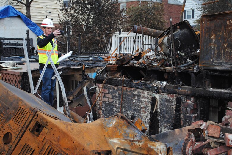 Josh Jimerfield, a debris engineer with the U.S. Army Corps of Engineers New York Recovery Field Office, takes a photo, Nov. 30, of a home burned to the ground on Beach 130th Street in Queens, N.Y. Teams of Army Corps and Federal Emergency Management Agency real estate specialists and field assessors are fanning out into neighborhoods of Queens, Brooklyn and Staten Island to meet homeowners and conduct site assessments.
