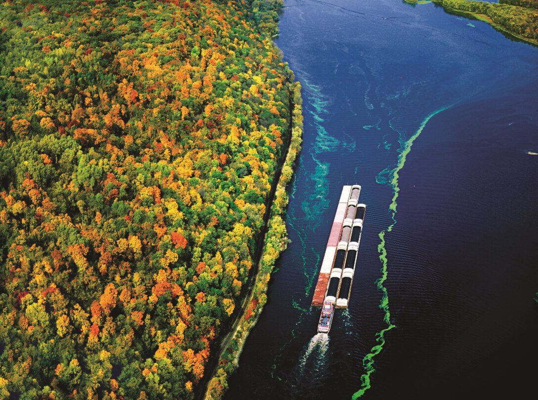 A barge heads along the Mississippi near the confluence of the Wisconsin River and a hillside in full autumn glory. Nearly 500 million tons of goods are tranported in barges on the basin's rivers each year.