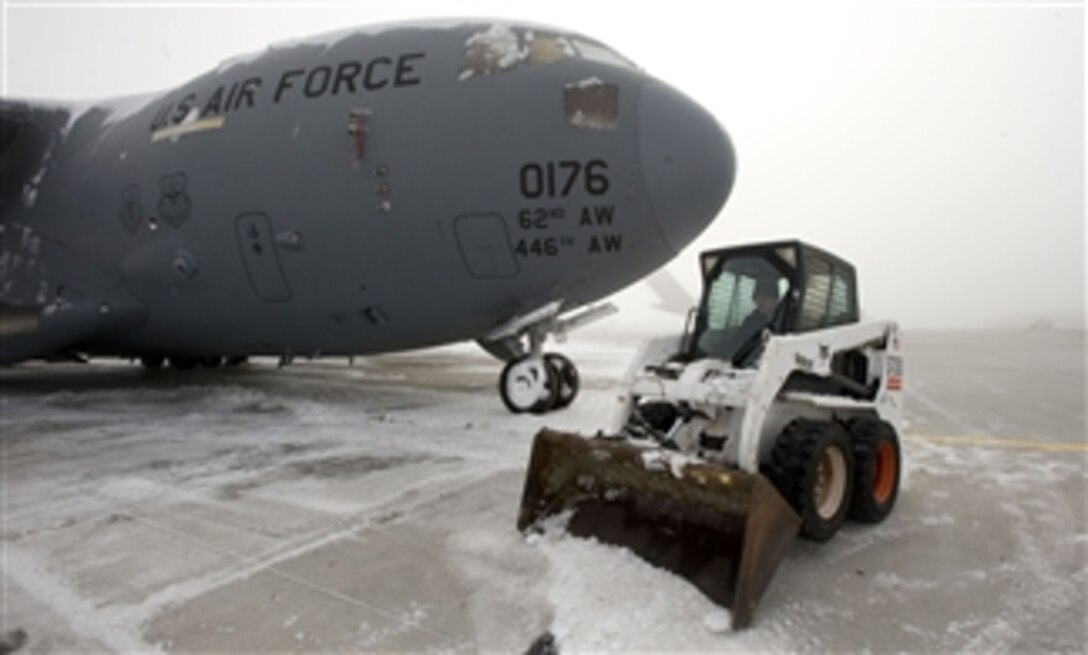 U.S. Air Force Staff Sgt. David MacGregor uses a Bobcat to clear snow away from a C-17 Globemaster III in Manas, Kyrgyzstan, on Nov. 21, 2012.  MacGregor is deployed to Manas from Dover Air Force Base, Del.   