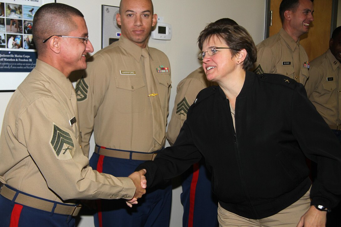 Rear Adm. Margaret Grun Kibben, Chaplain of the United States Marine Corps and the Deputy Chief of Navy Chaplains, gives a coin to Sgt. Giovanni Ocampo, a canvassing recruiter for Recruiting Sub Station Orange Park, for his participation in a question and answer session during Rear Adm. Kibben's visit to Recruiting Station Jacksonville, Fla, Nov. 30. 