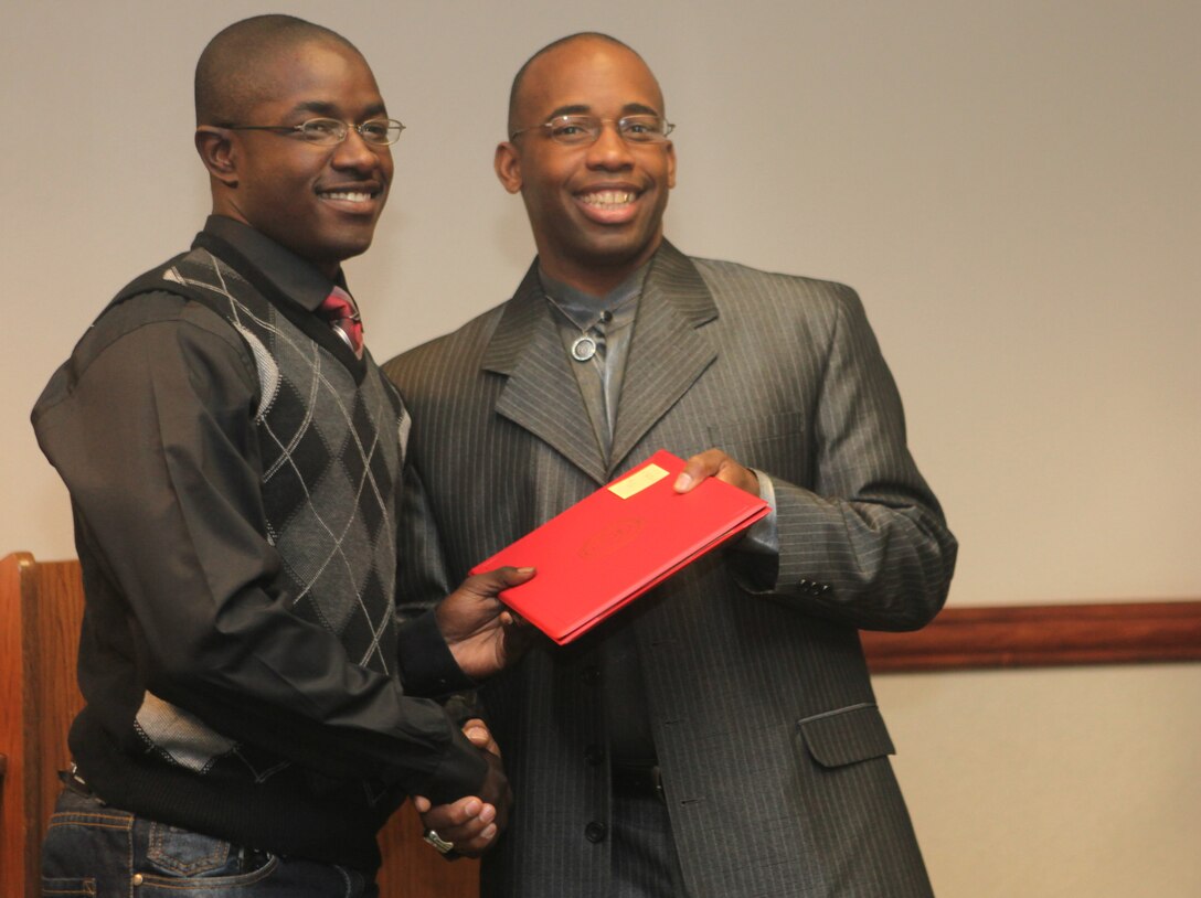 Master Gunnery Sgt. Carlice Moffett, right, assistant head coach of the Marine Corps Air Station Miramar Falcons, hands a player of the Falcons a certificate of participation during a banquet aboard Marine Corps Air Station Miramar, Calif., Dec. 1. All the players received a certificate of participation signed by the commanding officer and two team photos. 