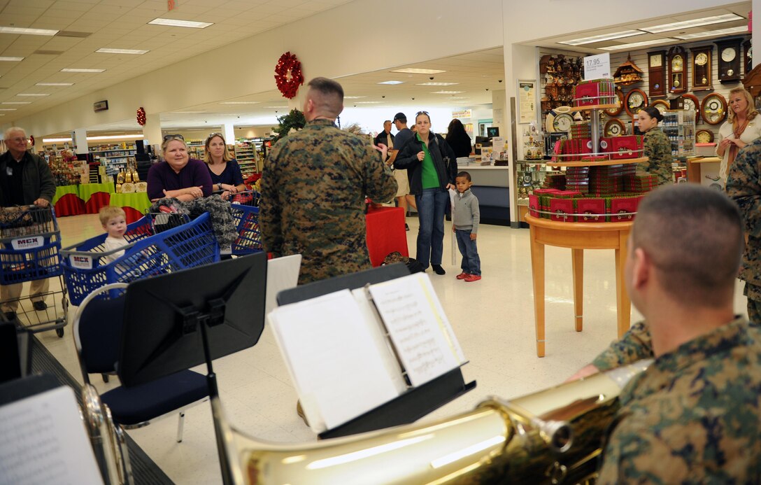 Staff Sgt. William Carr, euphonium player for the Marine Corps Base Quantico Band, introduces his tuba and euphonium choir to holiday shoppers at the Marine Corps Exchange on Monday. The ensemble performs for patrons performing classic hits like “Jingle Bells.”