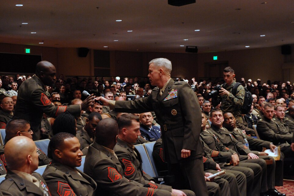 Gen. James F. Amos, commandant of the Marine Corps, hands with the microphone to a staff sergeant from the Marine Corps University during The Inaugural Thomas Lord Charitable Trust Lecture at Little Hall on Nov. 27. The lecture is to help broaden the students’ and faculty’s perspective on social, political, cultural and other topics that impact the nation or the global community.