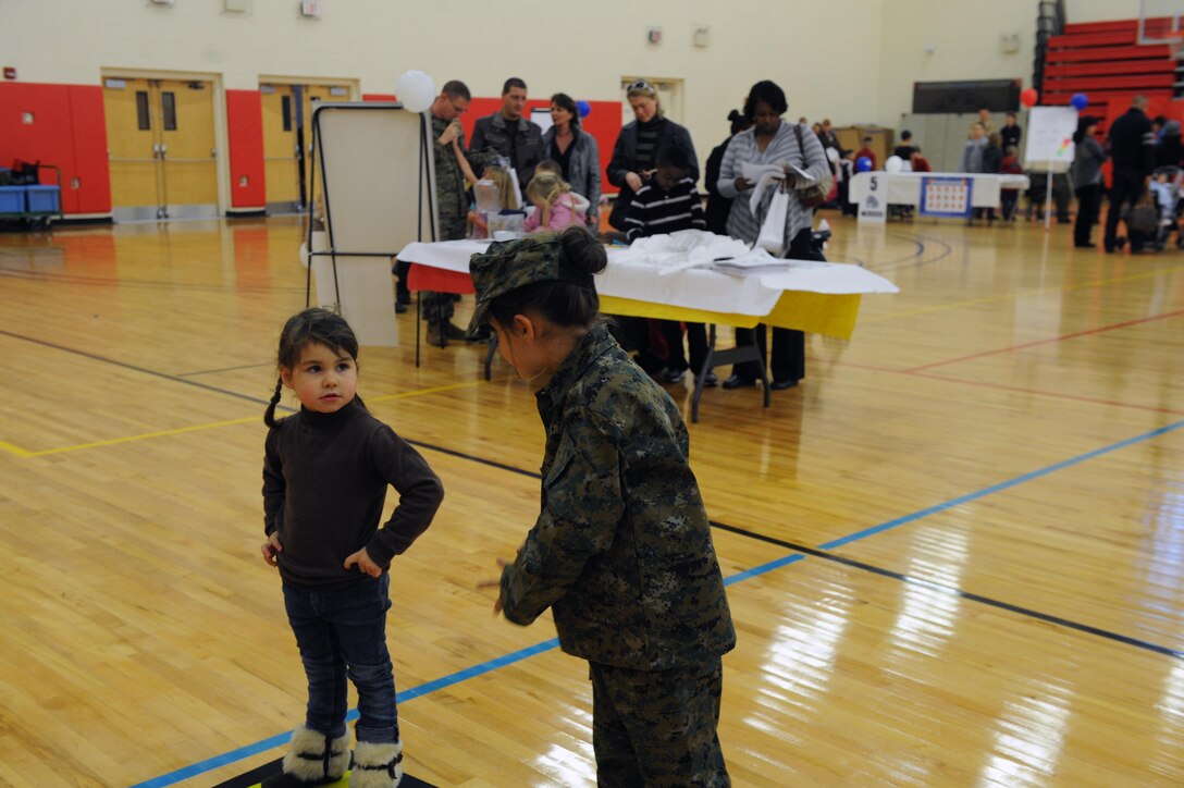 Clemence, 8, explains to her sister Hermine, 4, what to do during the first USMC Kids’ Birthday Bash was held at Barber Physical Activity Center on Nov. 8. The gym was set up with stations where children participated in numerous activities. 
