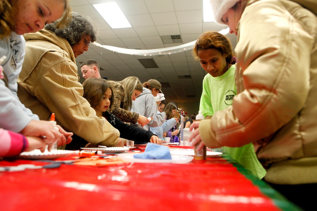 Children and parents create fun arts and crafts during the Tarawa Terrace Community Center Holiday Tree Lighting Ceremony at the Marine Corps Base Camp Lejeune housing community center Dec. 1. The craft table was just one of many different activities of the evening, which also including singing, dancing and a movie.