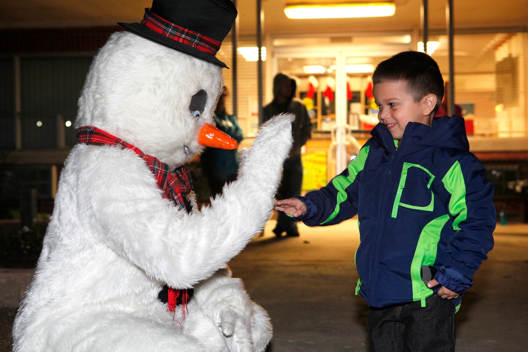 A boy shakes hands with Frosty the Snowman during the Tarawa Terrace Community Center Holiday Tree Lighting Ceremony at the Marine Corps Base Camp Lejeune housing community center Dec. 1. Frosty was one of the many lovable Christmas characters present at the tree lighting ceremony.