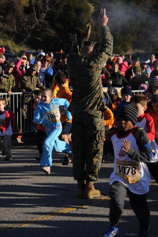 Col. James Brennan, Headquarters and Service Battalion Commanding Officer, fires the starting gun at the 28th Marine Corps Marathon Turkey Trot held aboard Marine Corps Base Quantico on Nov. 17. First and second place winners from each age and gender category received frozen turkeys and pumpkin pies, respectively.